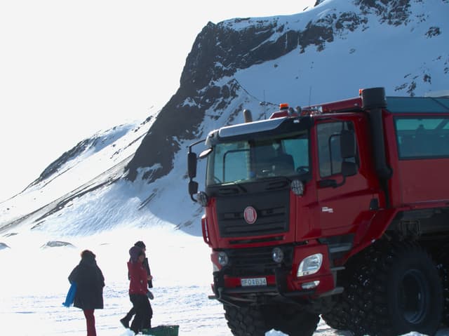 People-by-monster-truck-on-glacier