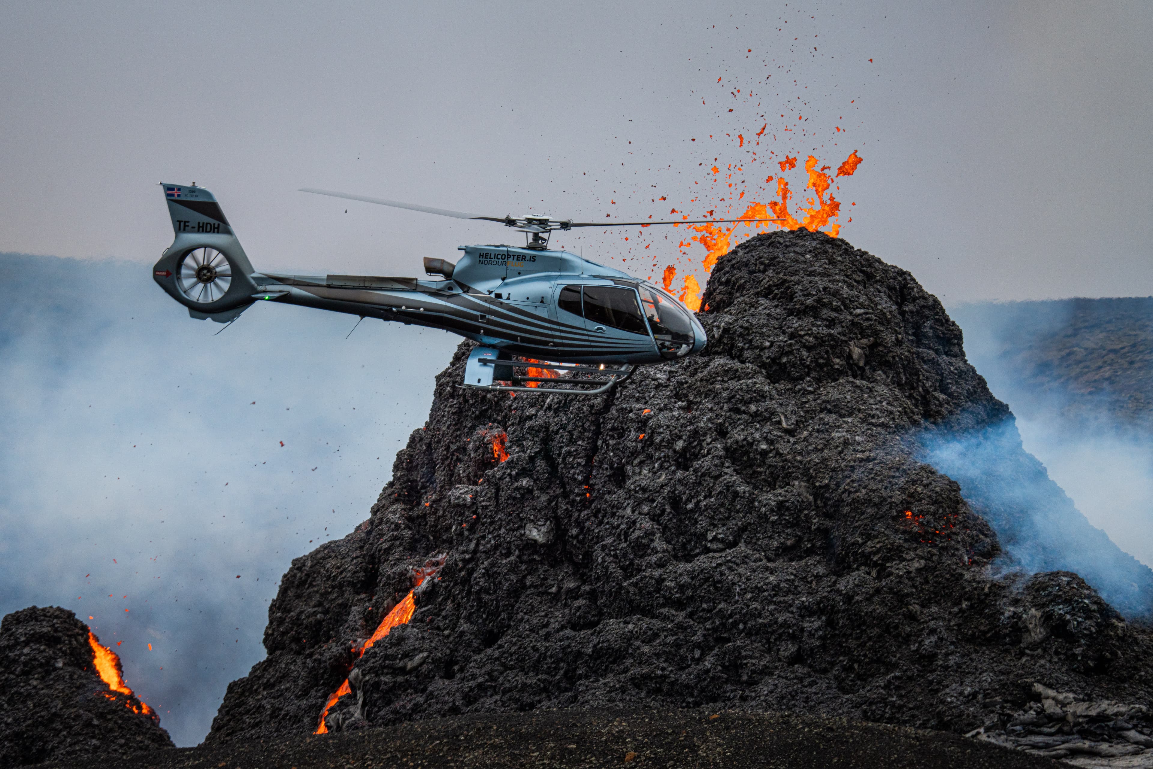 Helicopter-flying-by-Volcano-eruption