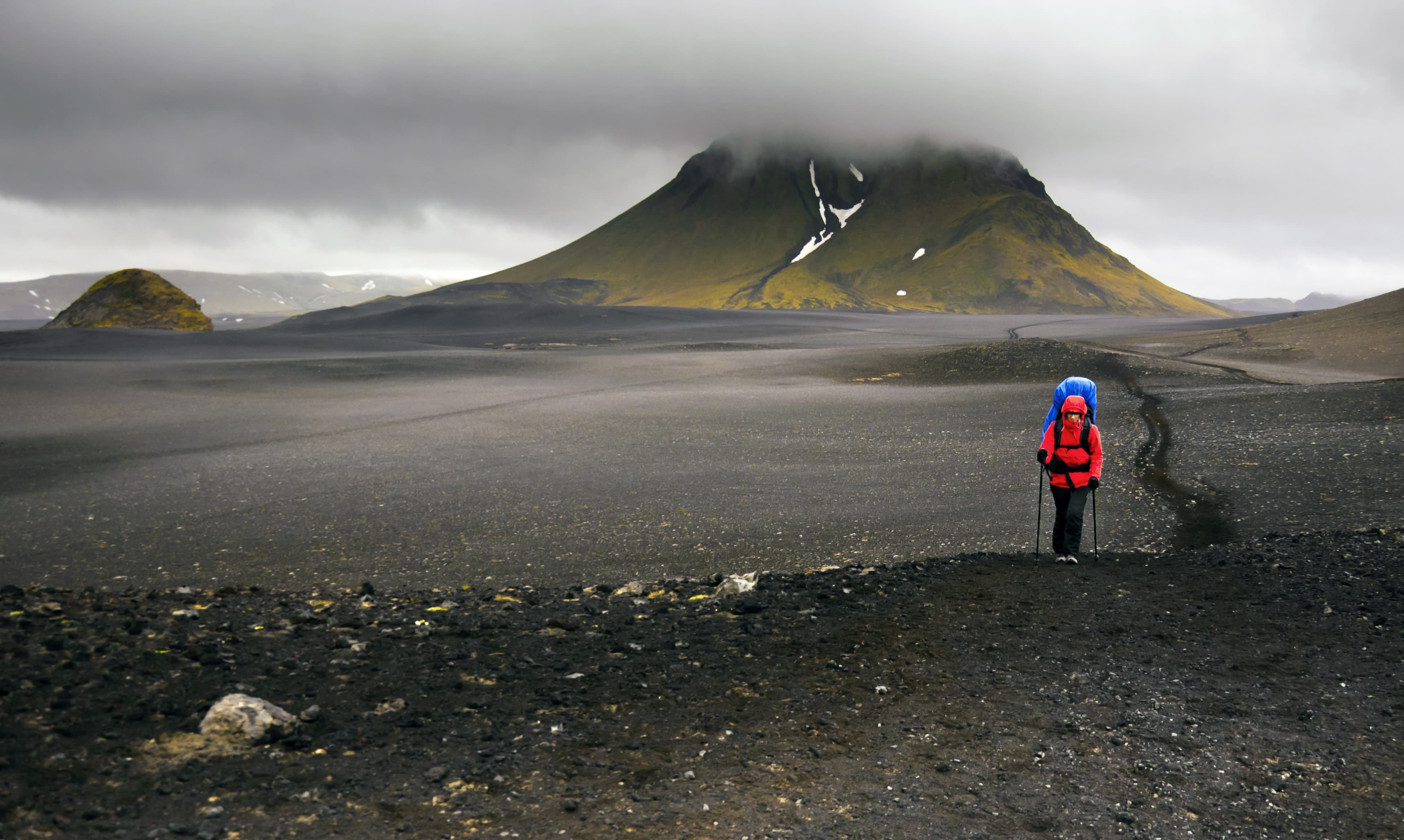 Hiker walking in black desert, Laugavegur trail in Iceland