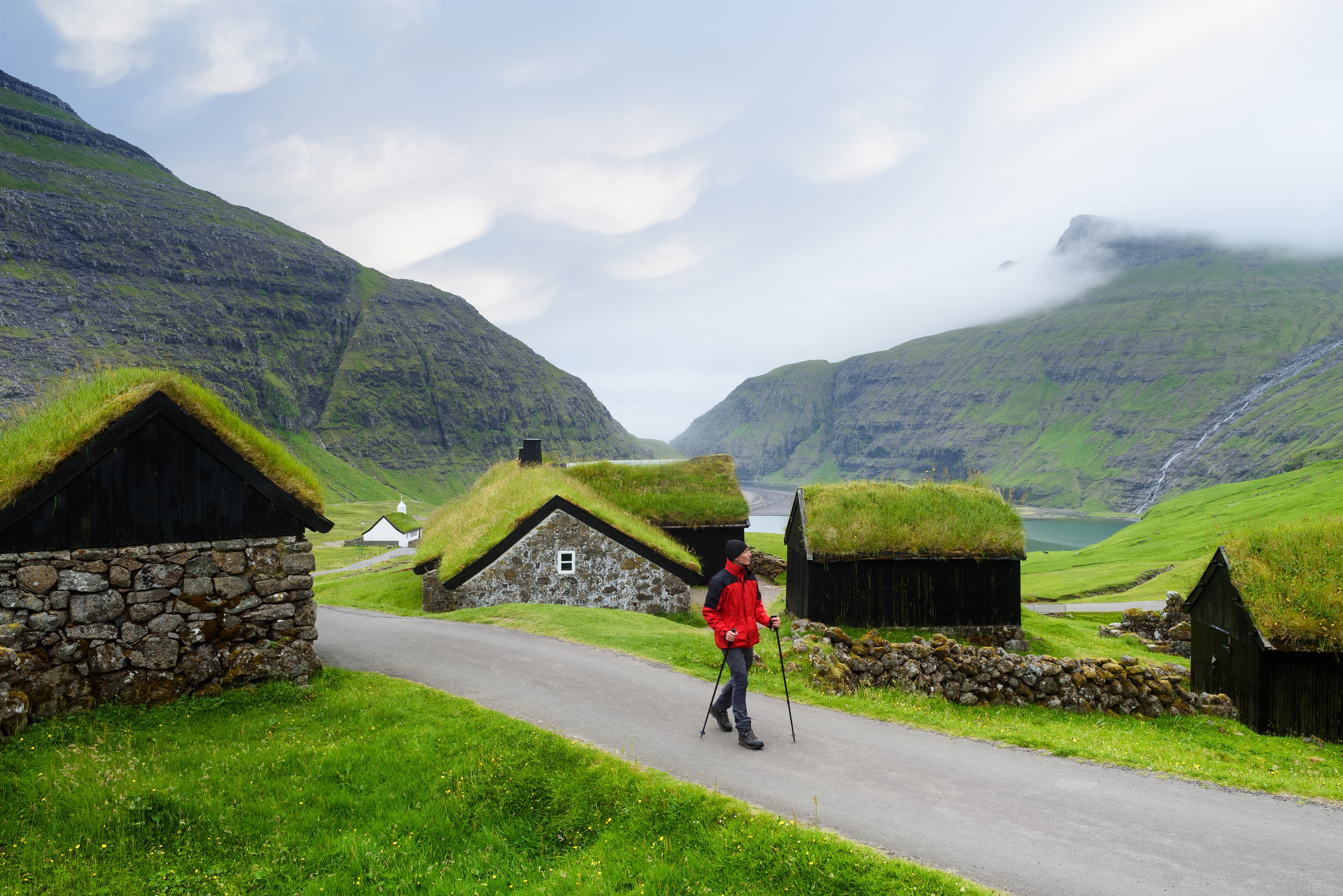 Saksun Village, Streymoy Island, Faroe islands, Kingdom of Denmark, Europe. Old stone houses with a grass roof. Tourist sightseeing in green valley Saksun village with turf roofed houses, Faroe islands