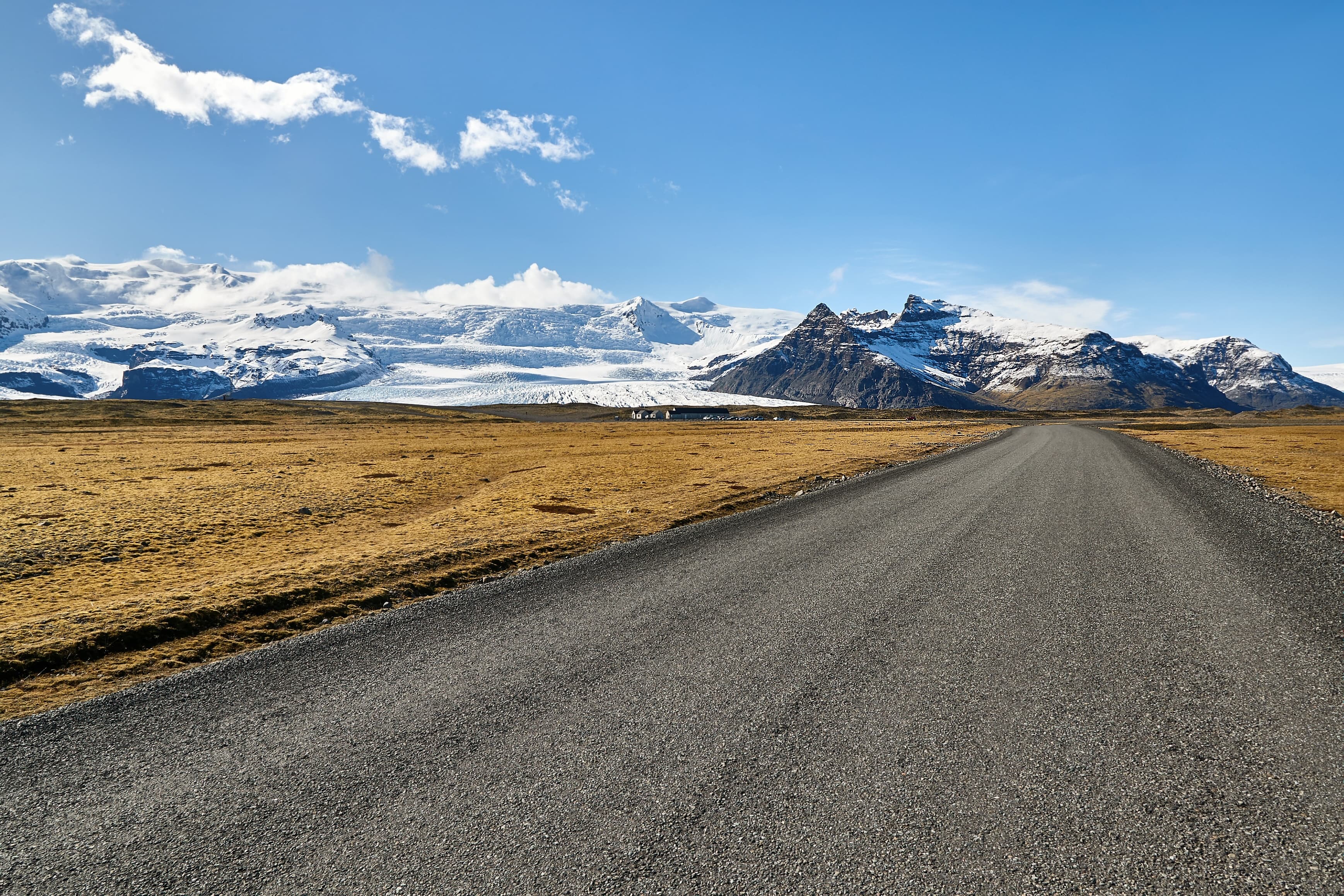 Gravel road in Iceland with mountains and glacier in the background Fjallsarlon-glacier-lagoon-zodiac-boat 8