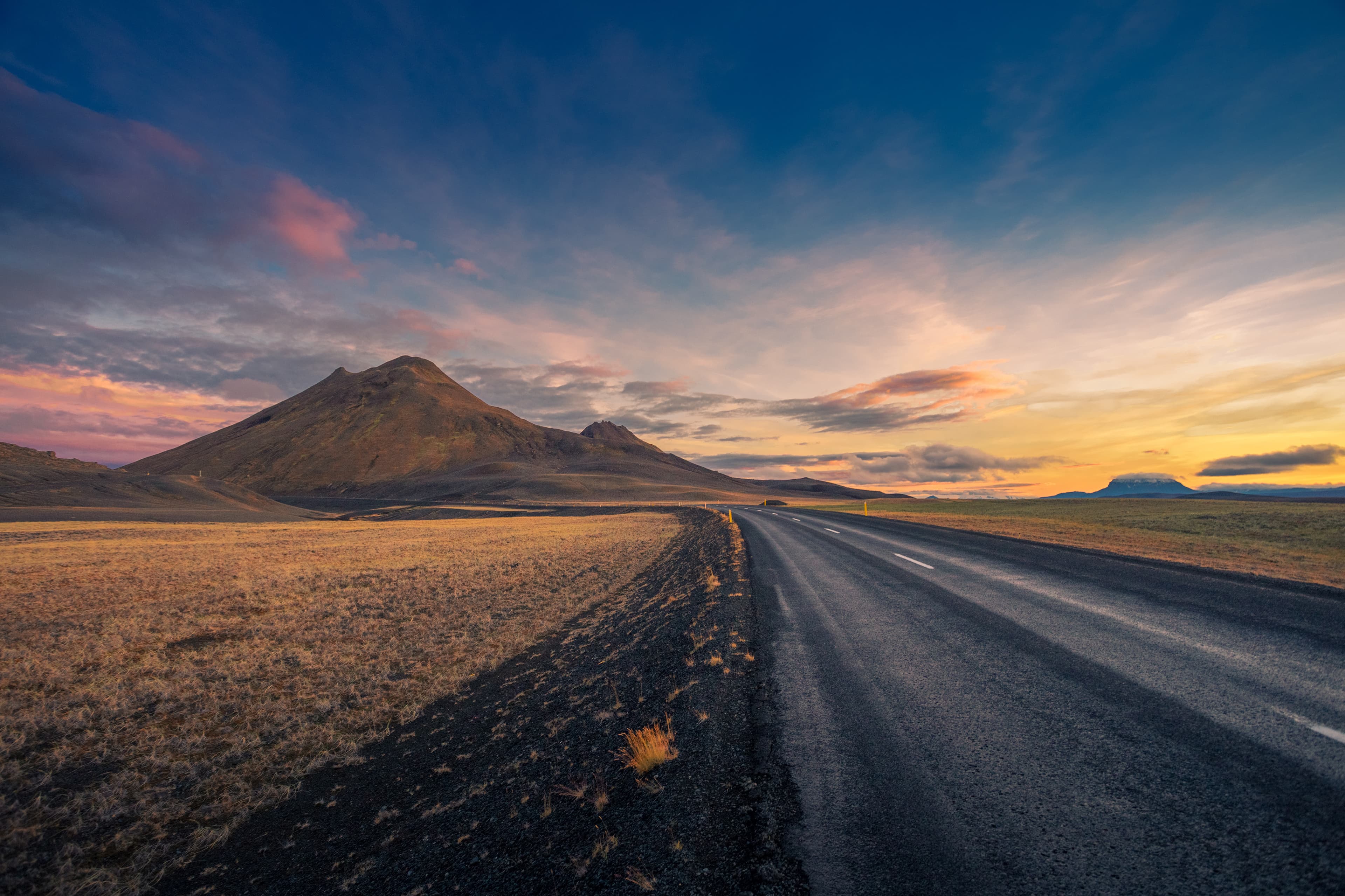 Iceland. Colorful landscape at sunset with dark road Iceland. Colorful landscape at sunset with dark road