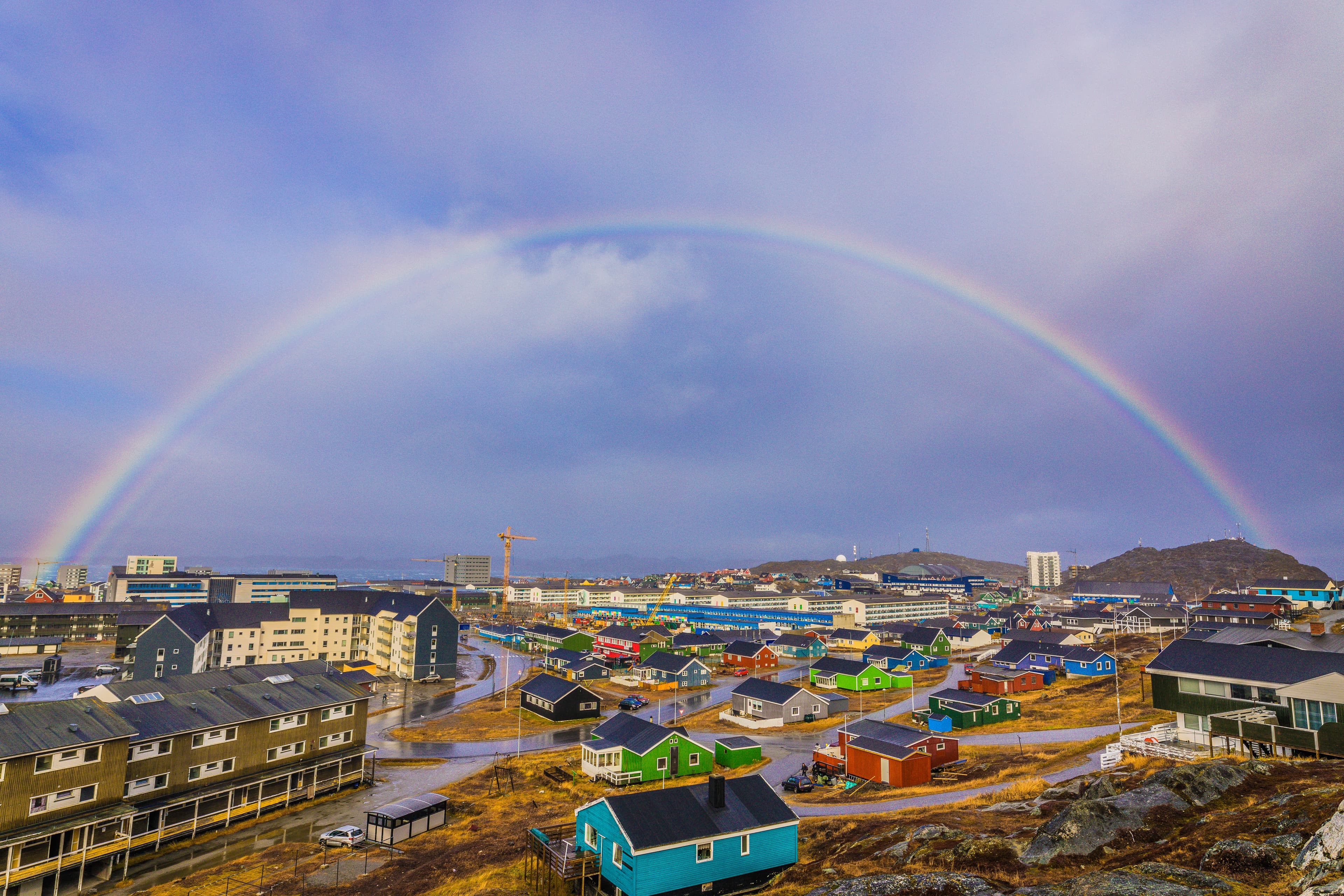 High Angle View Of Rainbow Over Buildings In City Against Sky