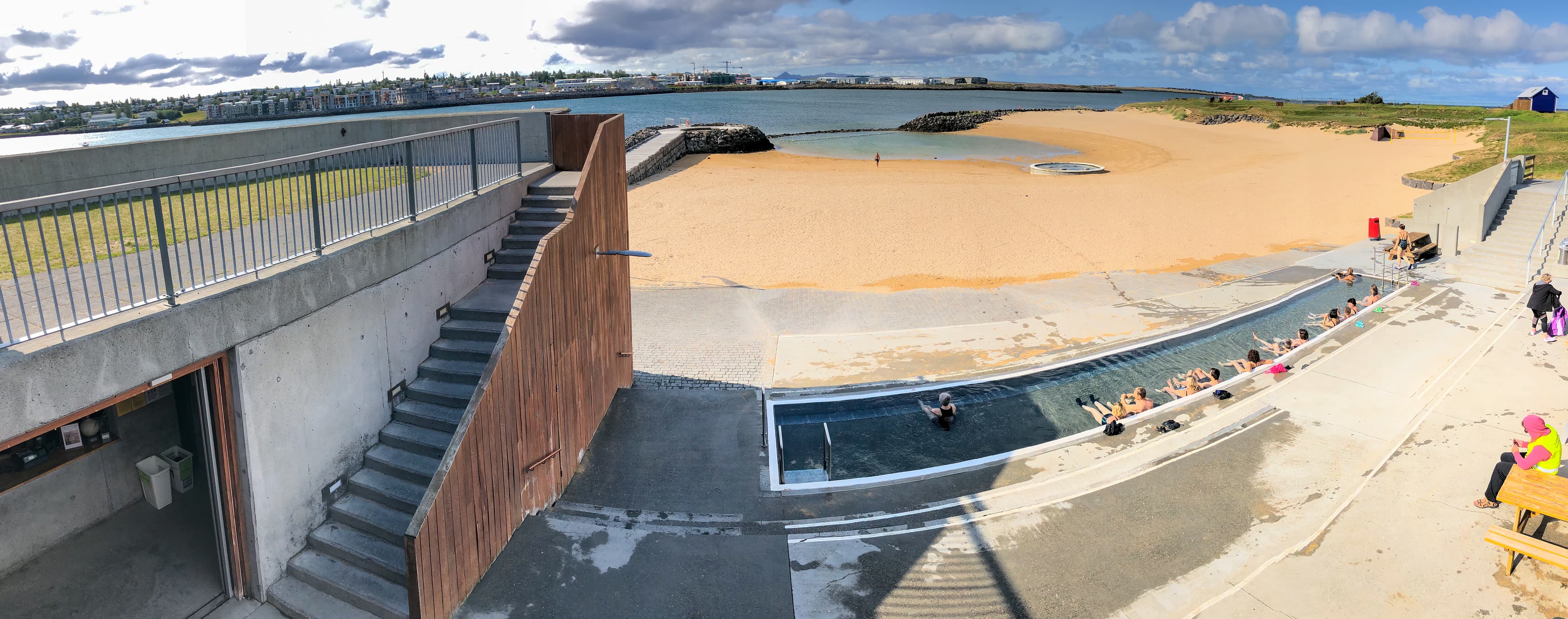 REYKJAVIK, ICELAND - AUGUST 11, 2019: Nautholsvik Geothermal Beach on a sunny summer day. It is a sandy beach with a man made hot spring. REYKJAVIK, ICELAND - AUGUST 11, 2019: Nautholsvik Geothermal Beach on a sunny summer day. It is a sandy beach with a man made hot spring