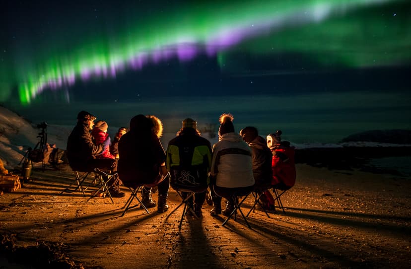People-sitting-by-the-fire-and-aurora-borealis