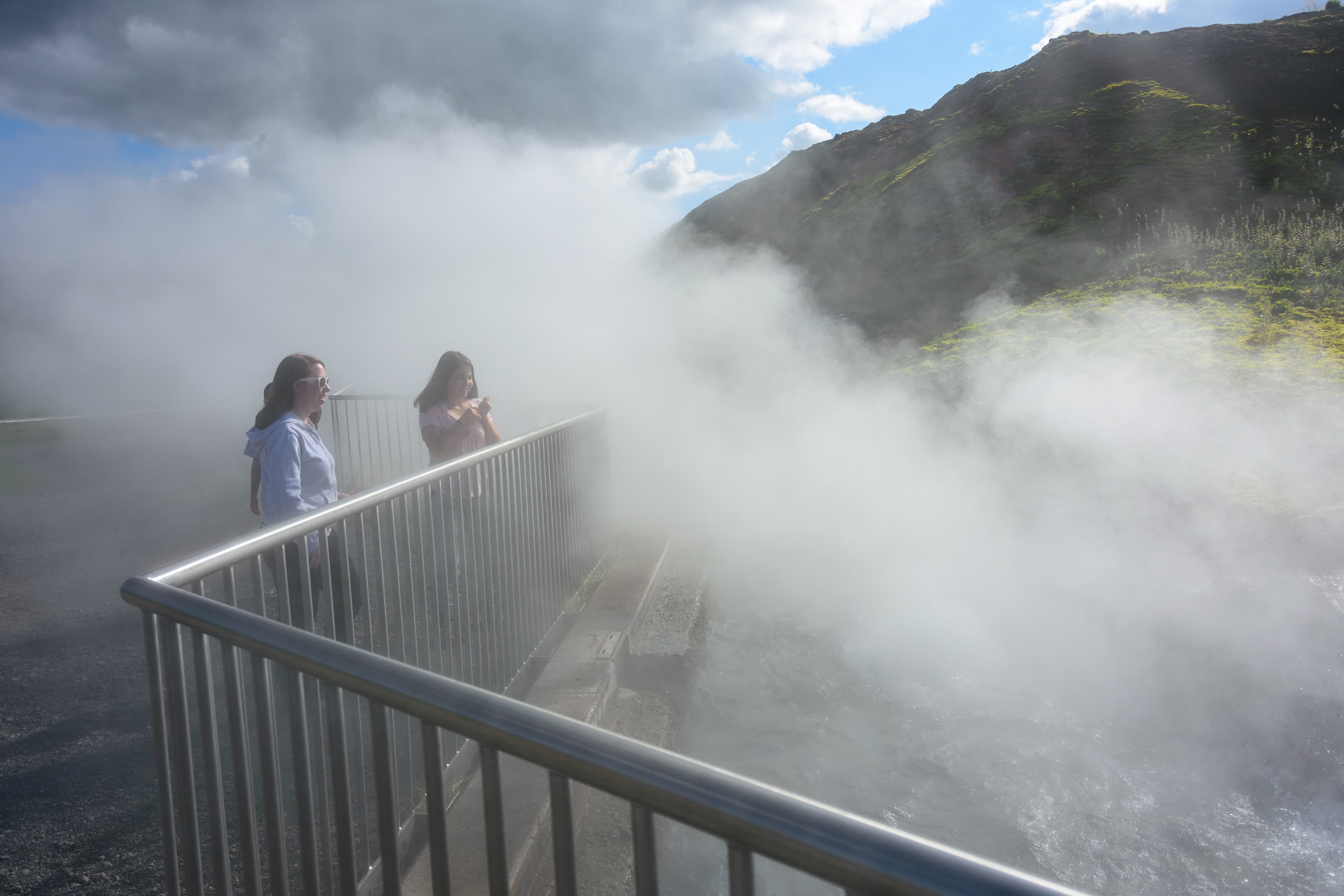 Two sisters admiring the Deildartunguhver Hot Springs in Iceland, where boiling water and steam in the largest quantity in Europe exit the ground Deildartunguhver Hot Springs in Iceland