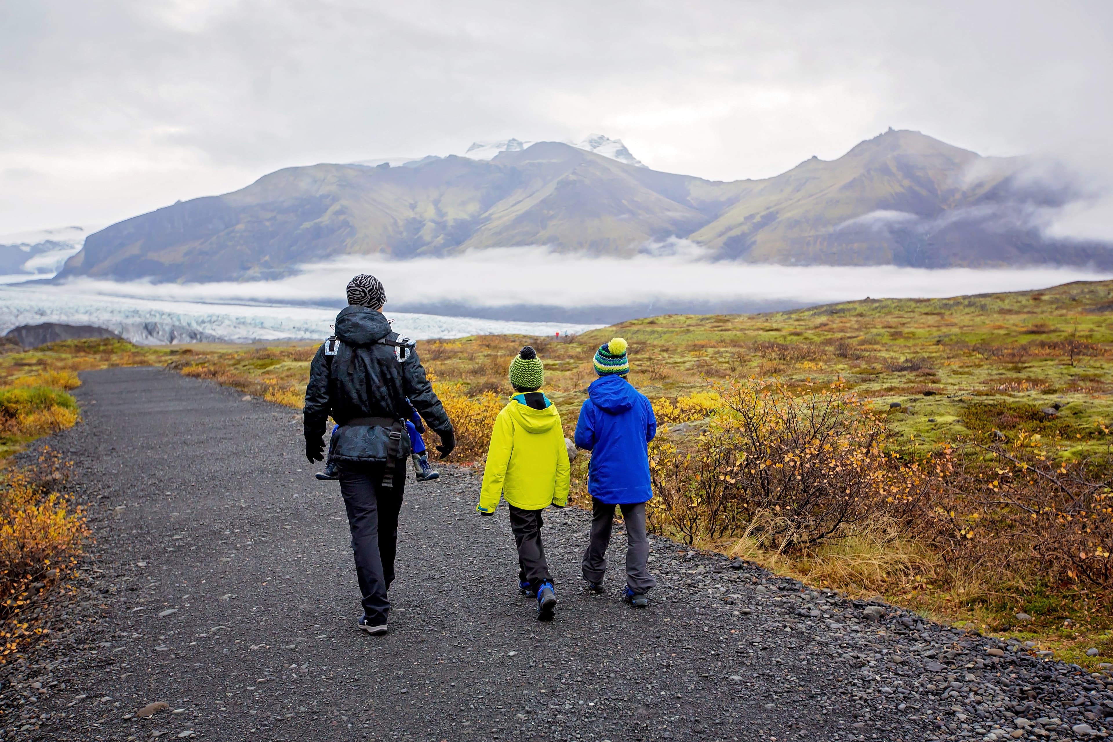 Father with children, walking on a path in beautiful nature of Skaftafell Glacier national park on a gorgeous autumn day in Iceland, autumntime Father with children, walking on a path in beautiful nature of Skaftafell Glacier national park on a gorgeous autumn day in Iceland