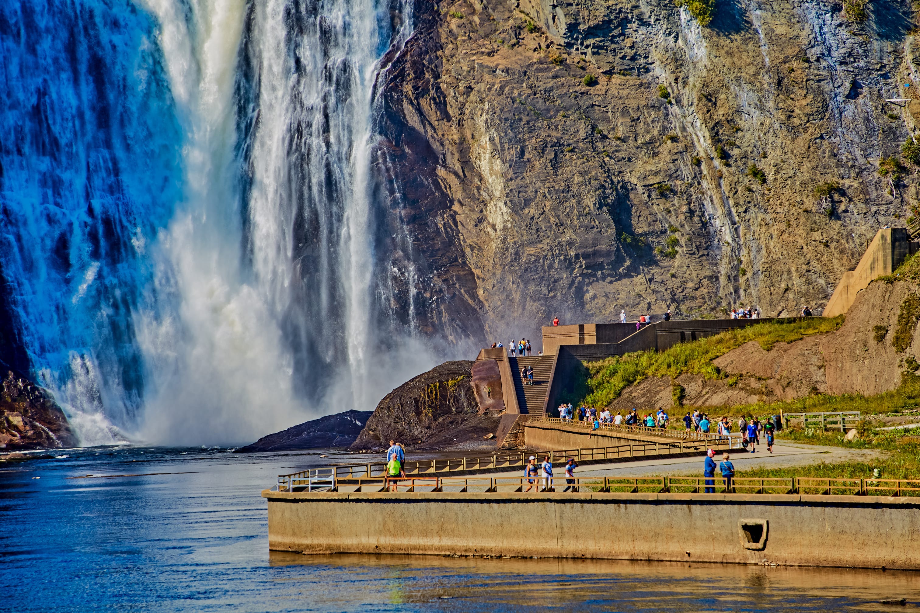 QUEBEC, CANADA - September 16, 2018: The Montmorency Falls is a waterfall on the Montmorency River in Quebec, Canada. The many tourists that visit there are treated to many ways to see the falls People at Bottom of Montmorency Falls