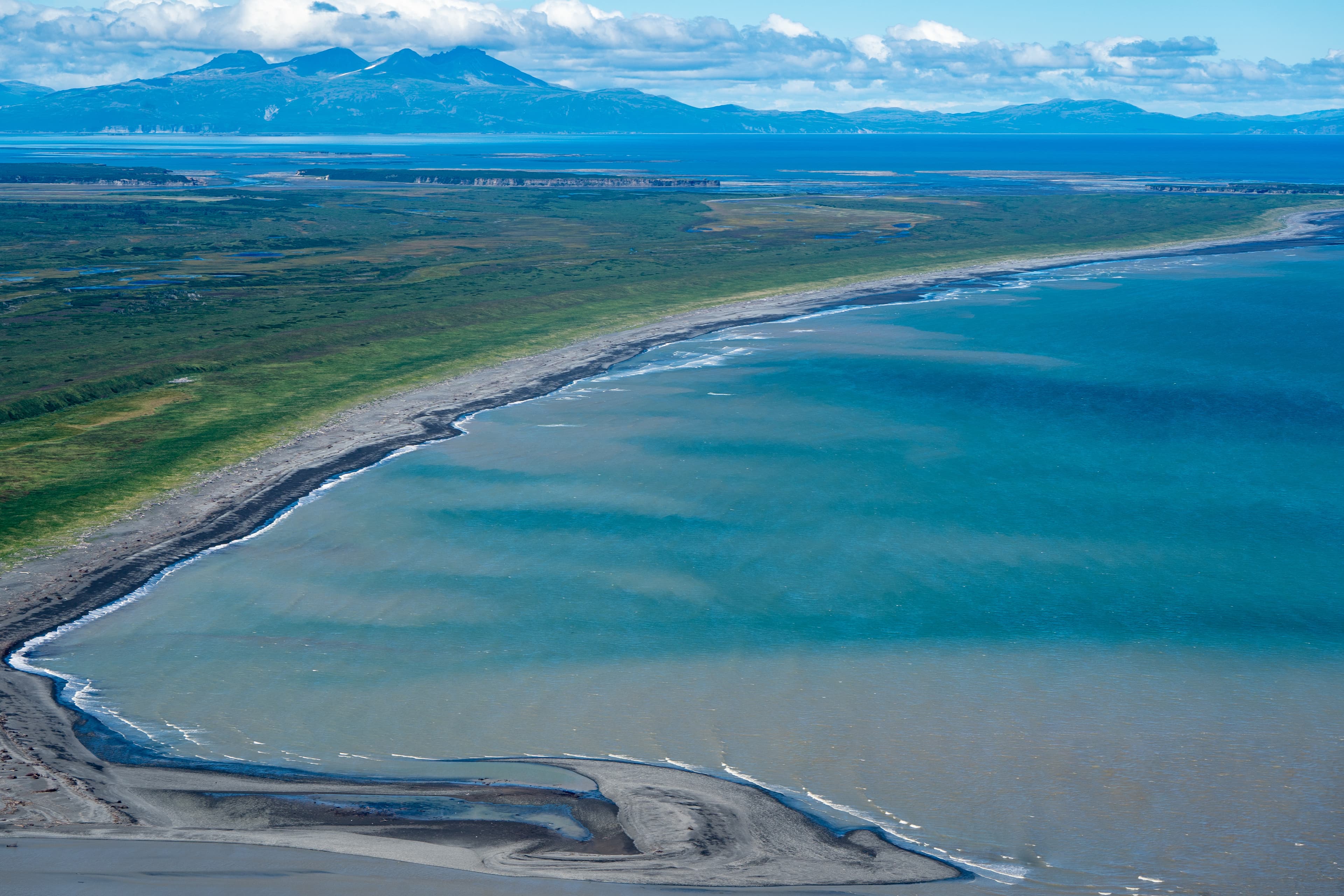 Aerial photography view of Alaska's Katmai National Park. Teal water, lush green mountain vegetation and sandbars into the Cook Inlet Aerial photography view of Alaska Katmai National Park