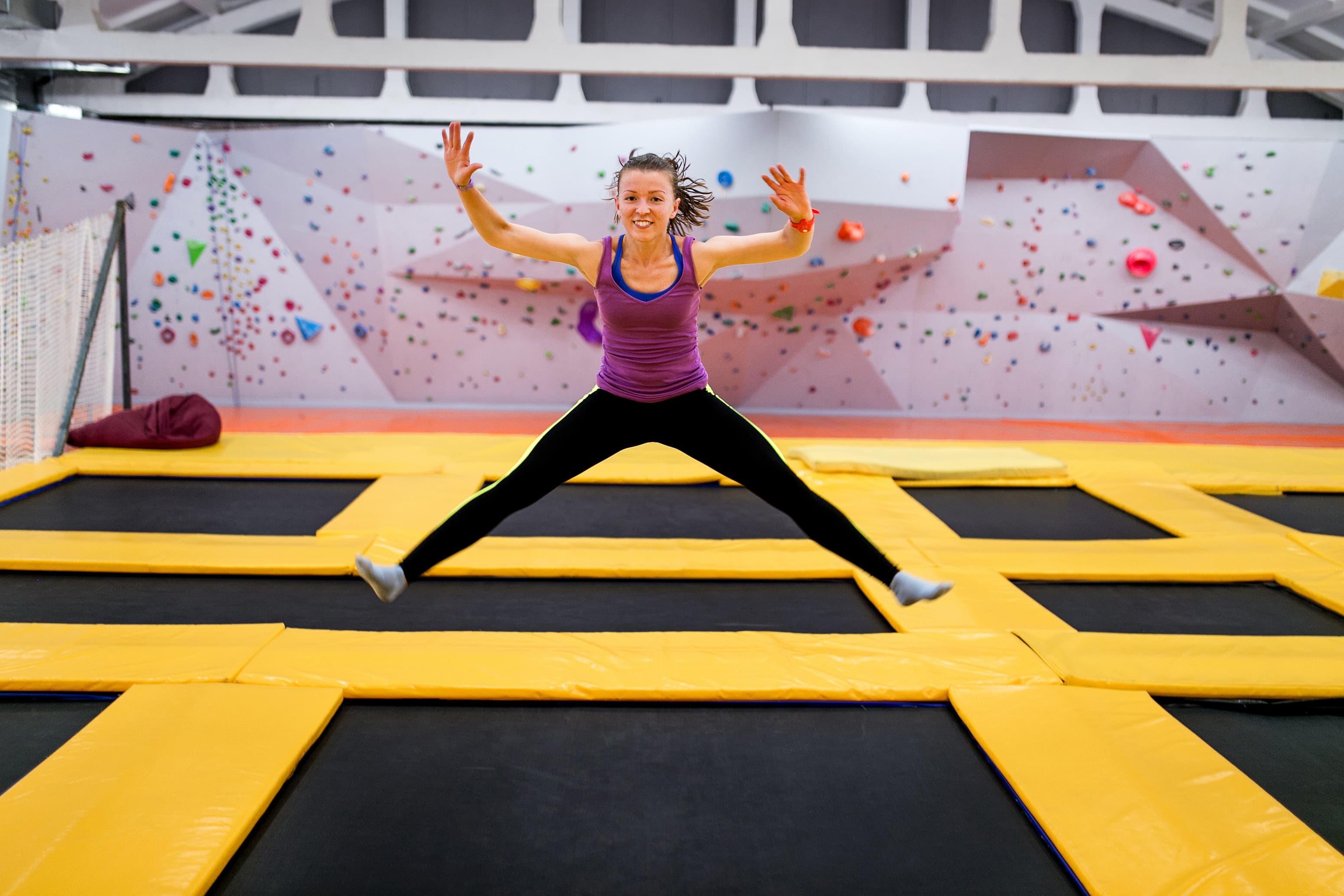 Young sportsman jumping on a trampoline and doing split indoors Young sportsman jumping on a trampoline and doing split indoors
