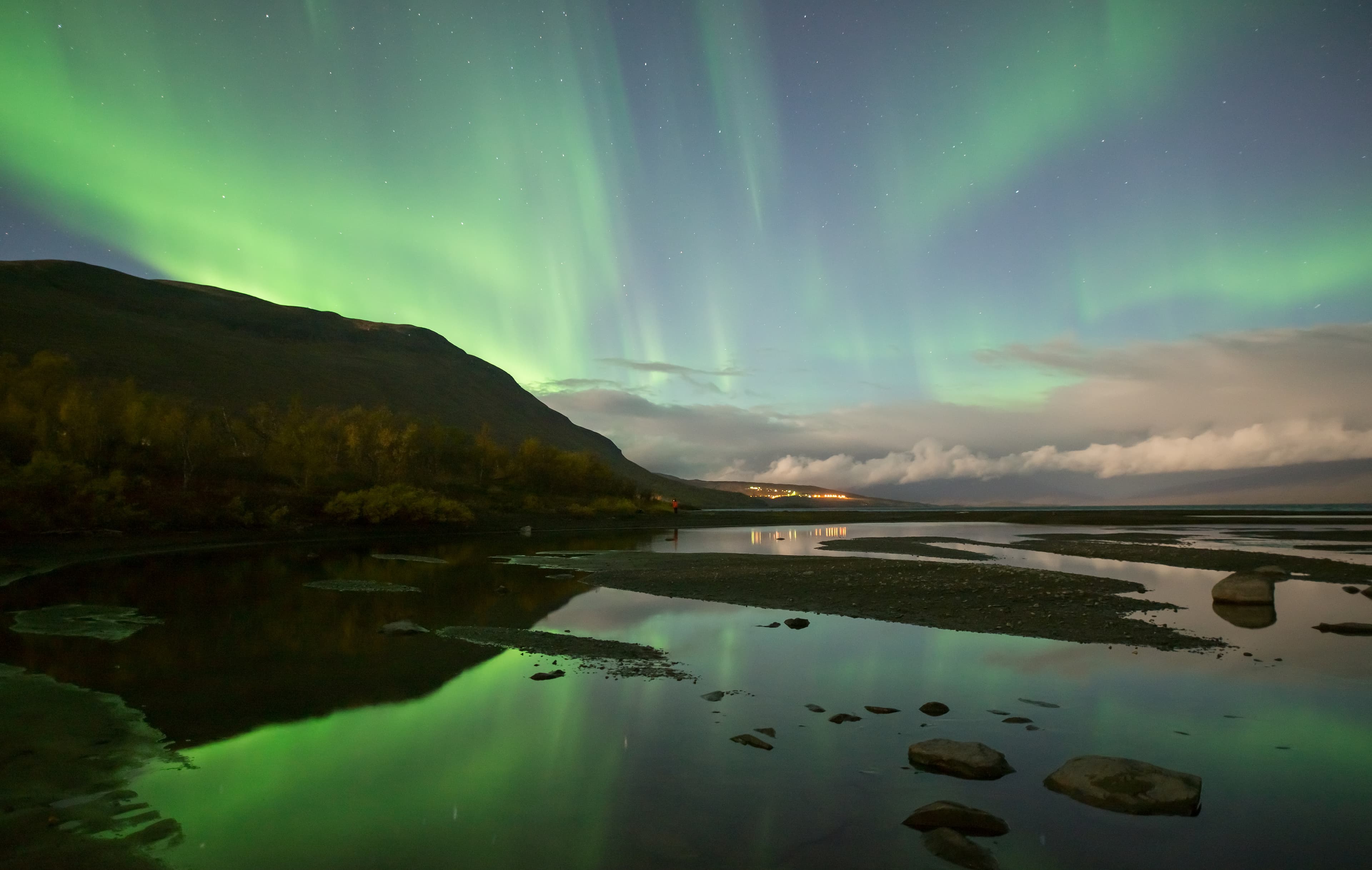 Northern lights dancing over calm lake in Abisko national park