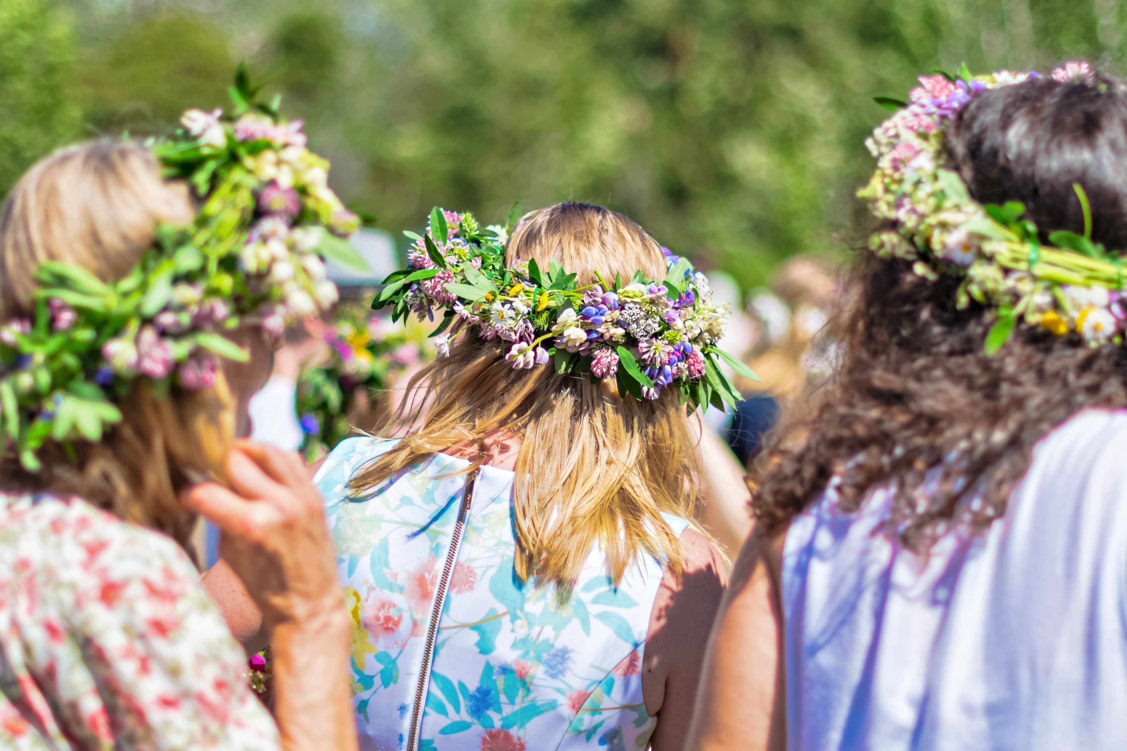 SINGO, SWEDEN, JUNE 21, 2019: Midsummer with women wearing wraths during a clear and sunny day in Sweden. Midsummer with women wearing wraths during a clear and sunny day in Sweden