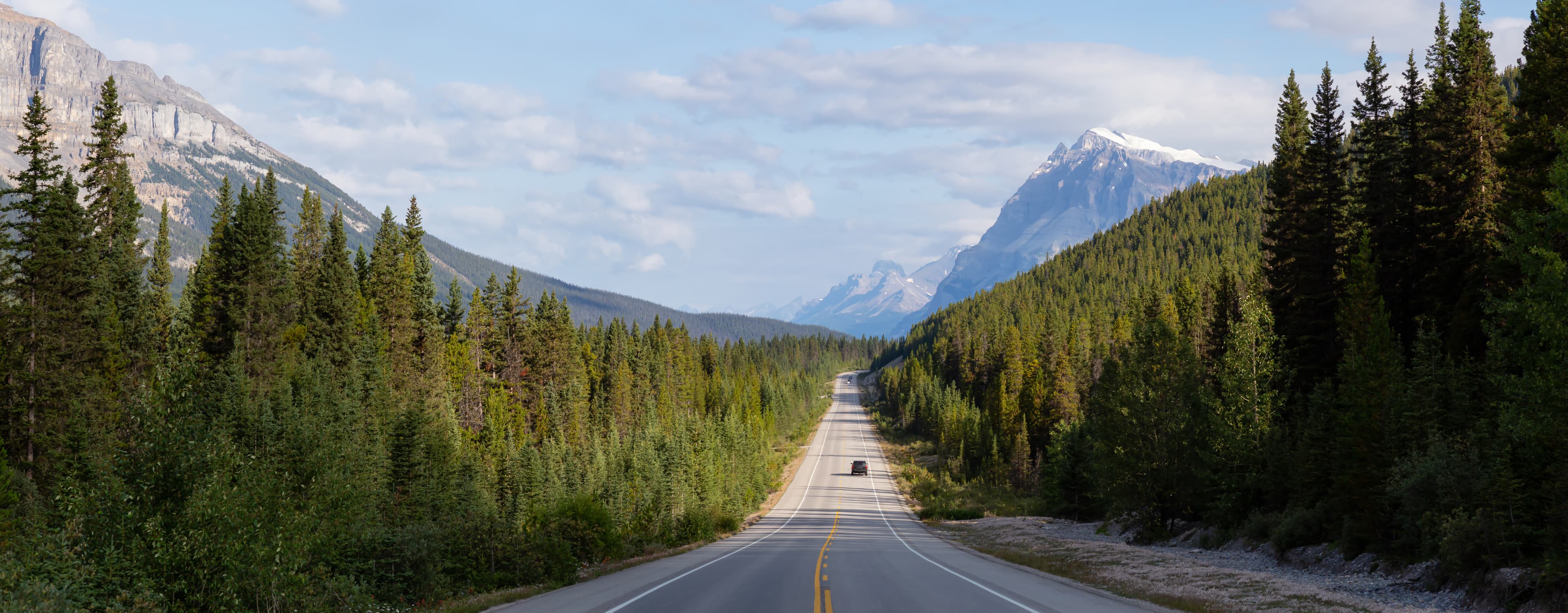 Panoramic View of a Scenic road in the Canadian Rockies during a vibrant sunny and cloudy summer morning. Taken in Icefields Parkway, Banff National Park, Alberta, Canada. Panoramic View of a Scenic road in the Canadian Rockies during a vibrant sunny and cloudy summer morning. Taken in Icefields Parkway, Banff National Park, Alberta, Canada.