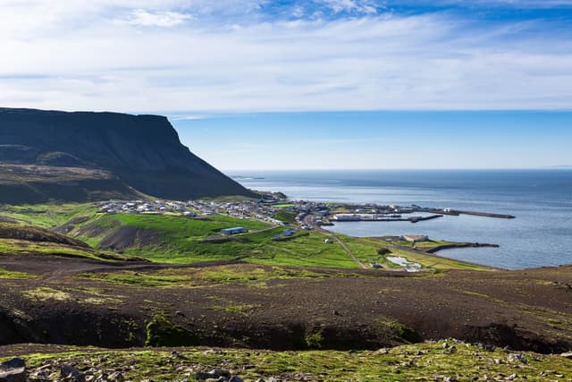 Olafsvik village in Snaefelsness peninsula, Iceland. Icelandic landscape with small village on the seashore with huge cliff above it. Olafsvik village in Snaefelsness peninsula, Iceland. Icelandic landscape with small village on the seashore with huge cliff above it.