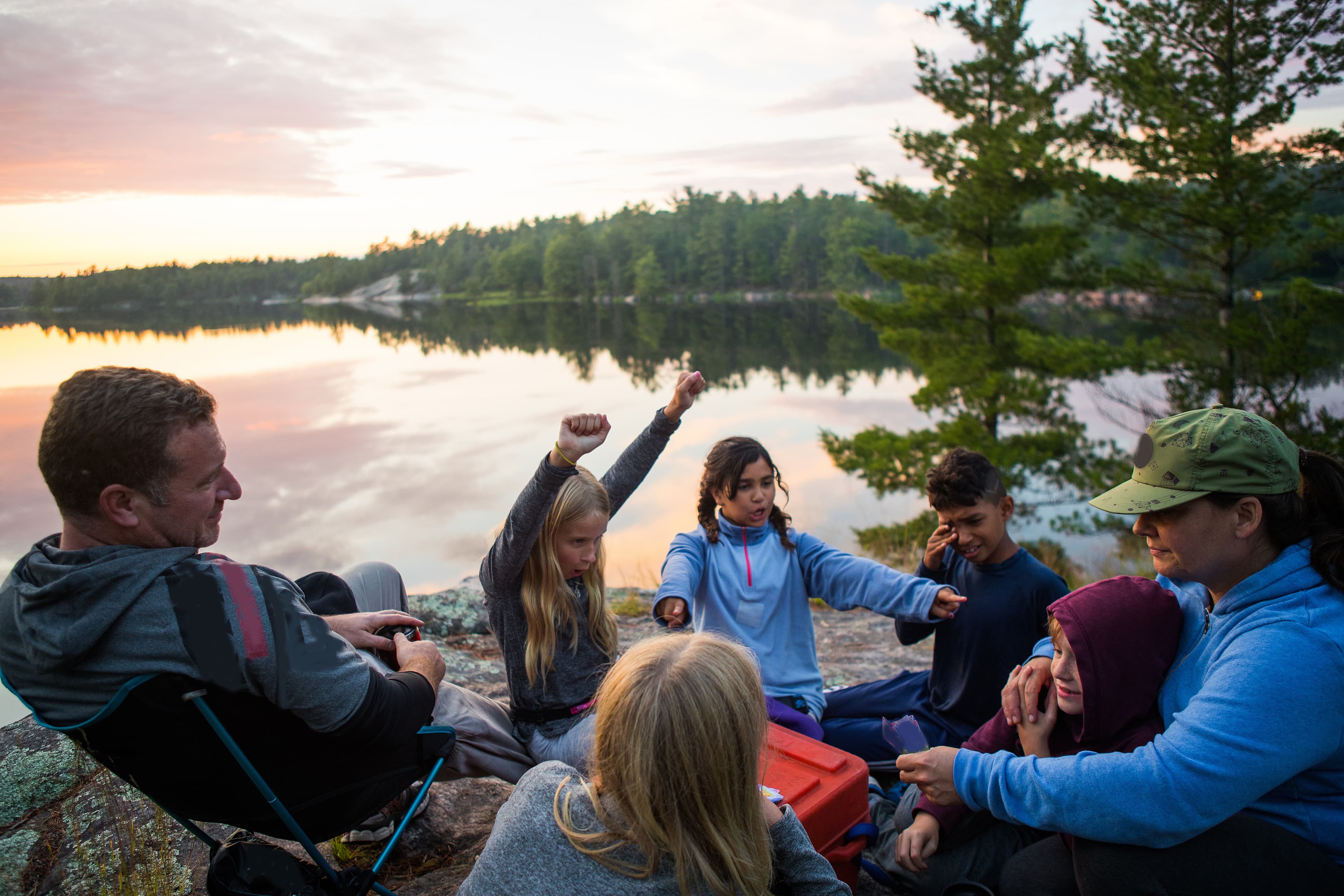 Kids play on the shore during a multi ethnic family canoe trip Kids playing during a family camping trip