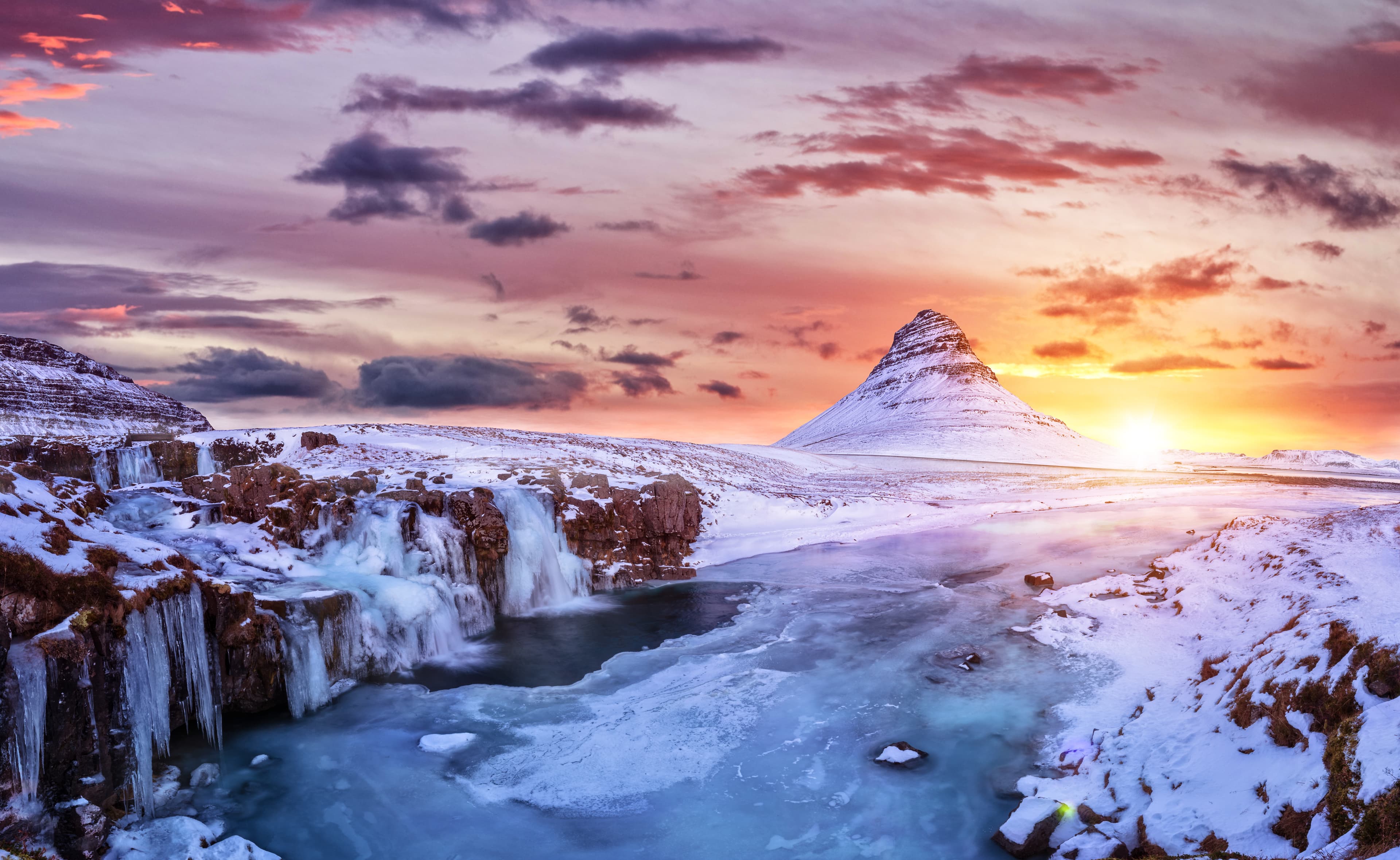Kirkjufell mountain with frozen water falls in winter, Iceland. One of the famous natural heritage in Iceland. Kirkjufell mountain with frozen water falls in winter