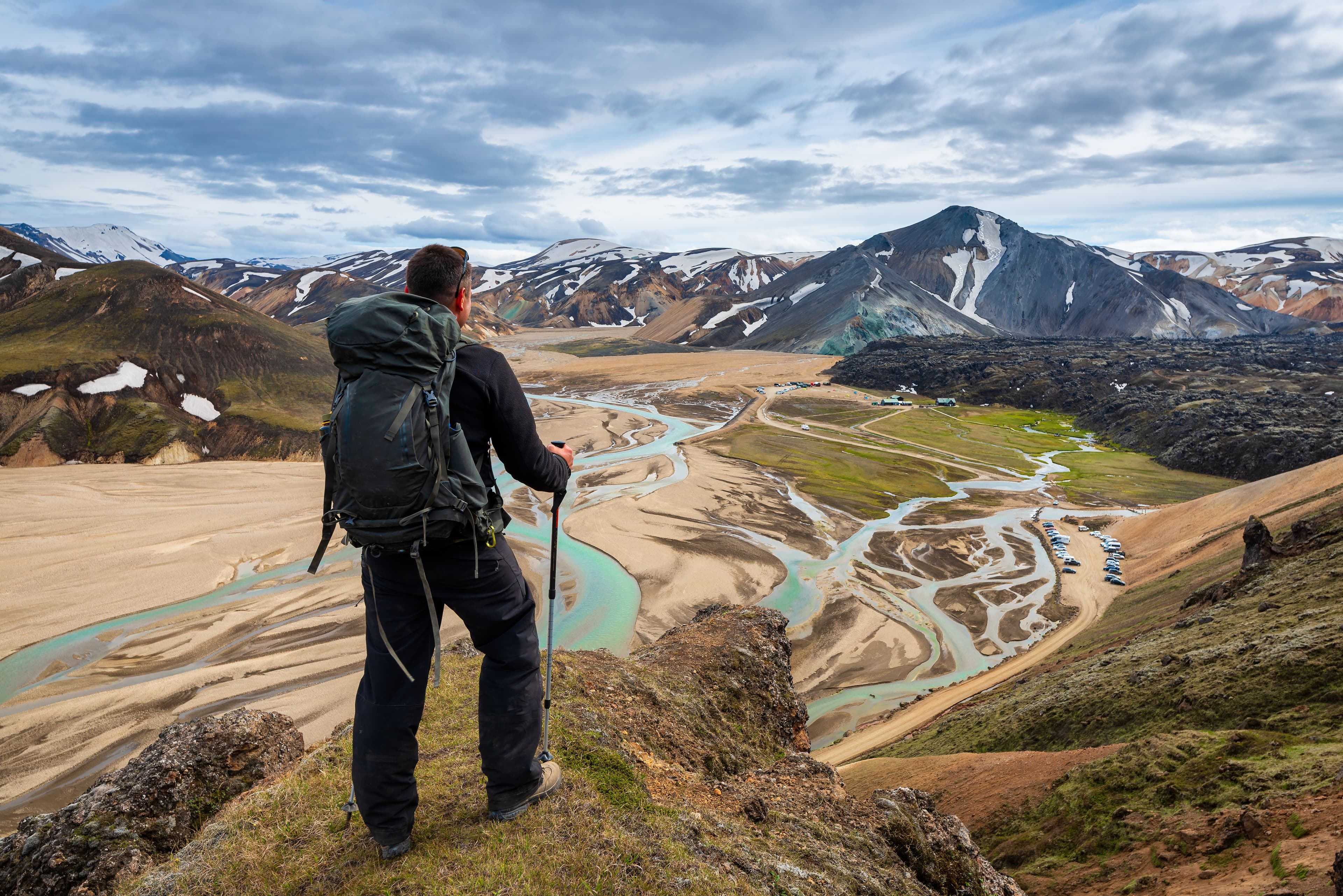 The man hiker looking at the camp in Landmannalaugar, Iceland The man hiker looking at the camp in Landmannalaugar, Iceland