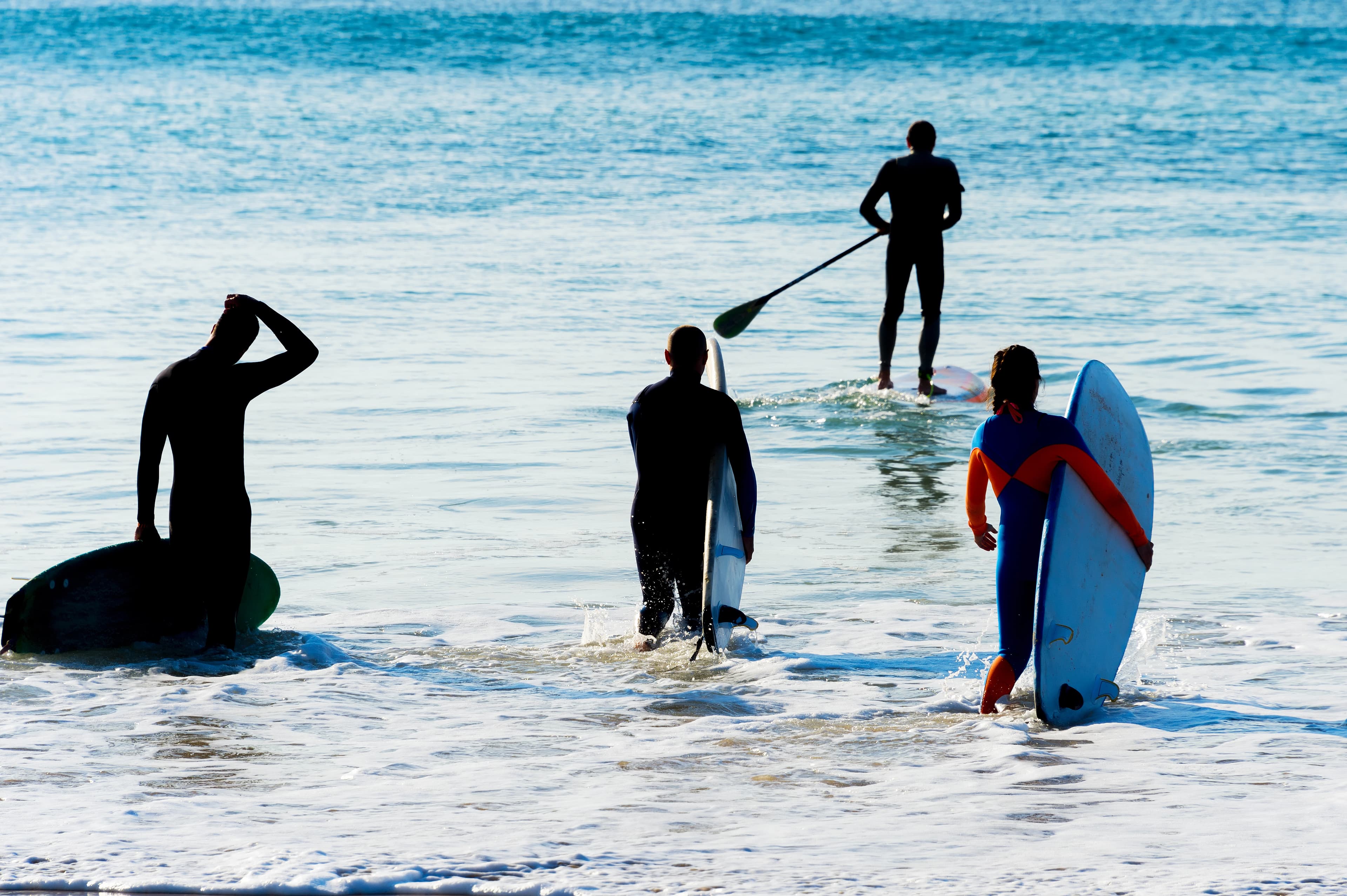 Group of surfers going to surf. SIlhouette. Peniche, Portugal Group surfers going  surf SIlhouette.