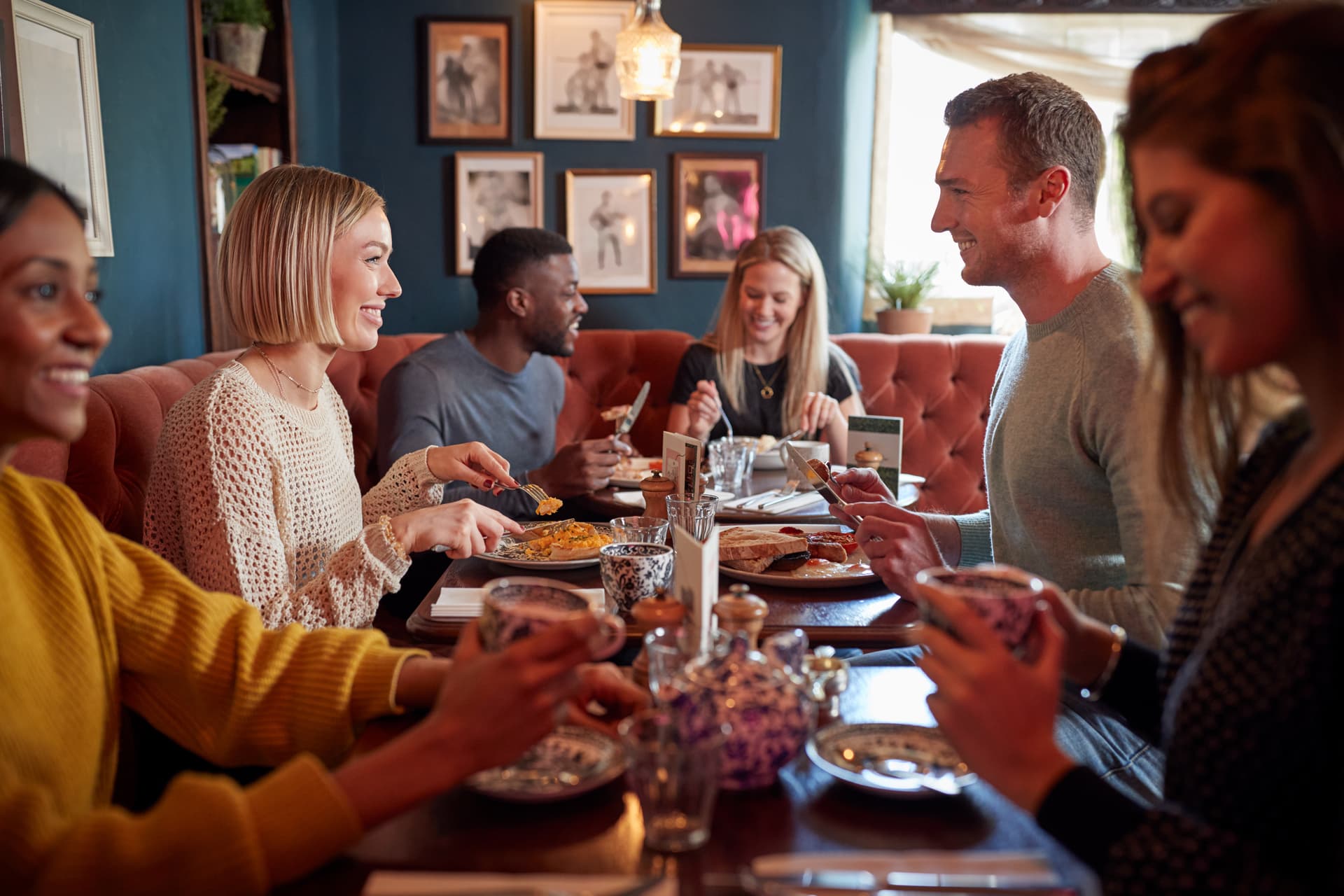 Group Of People Eating In Restaurant Of Busy Traditional English Pub iceland-tours
