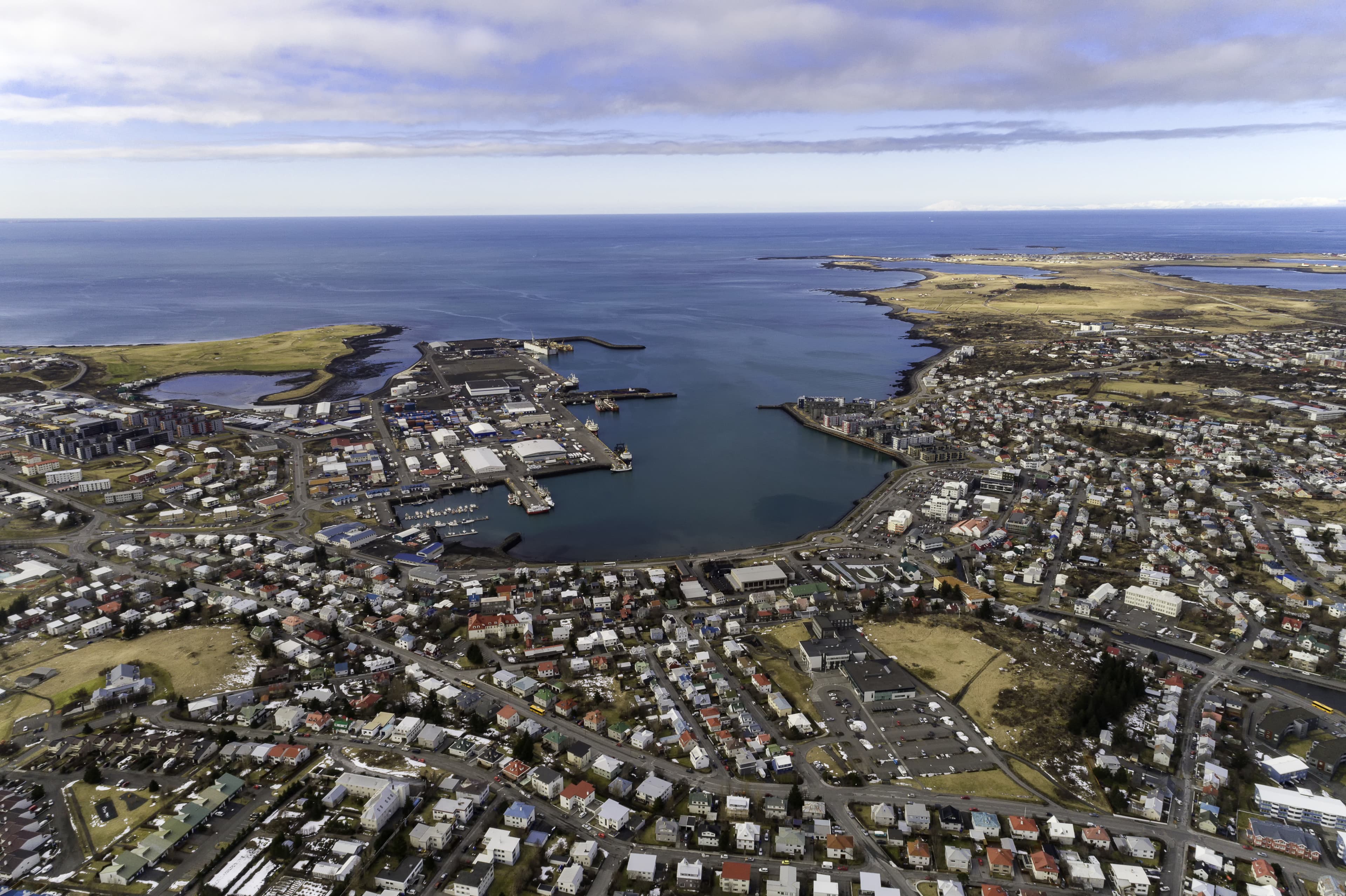 Aerial shot of the town of Hafnarfjordur close to Reykjavik city Iceland, looking out over the harbor and ocean Aerial of Hafnarfjordur town in the lava