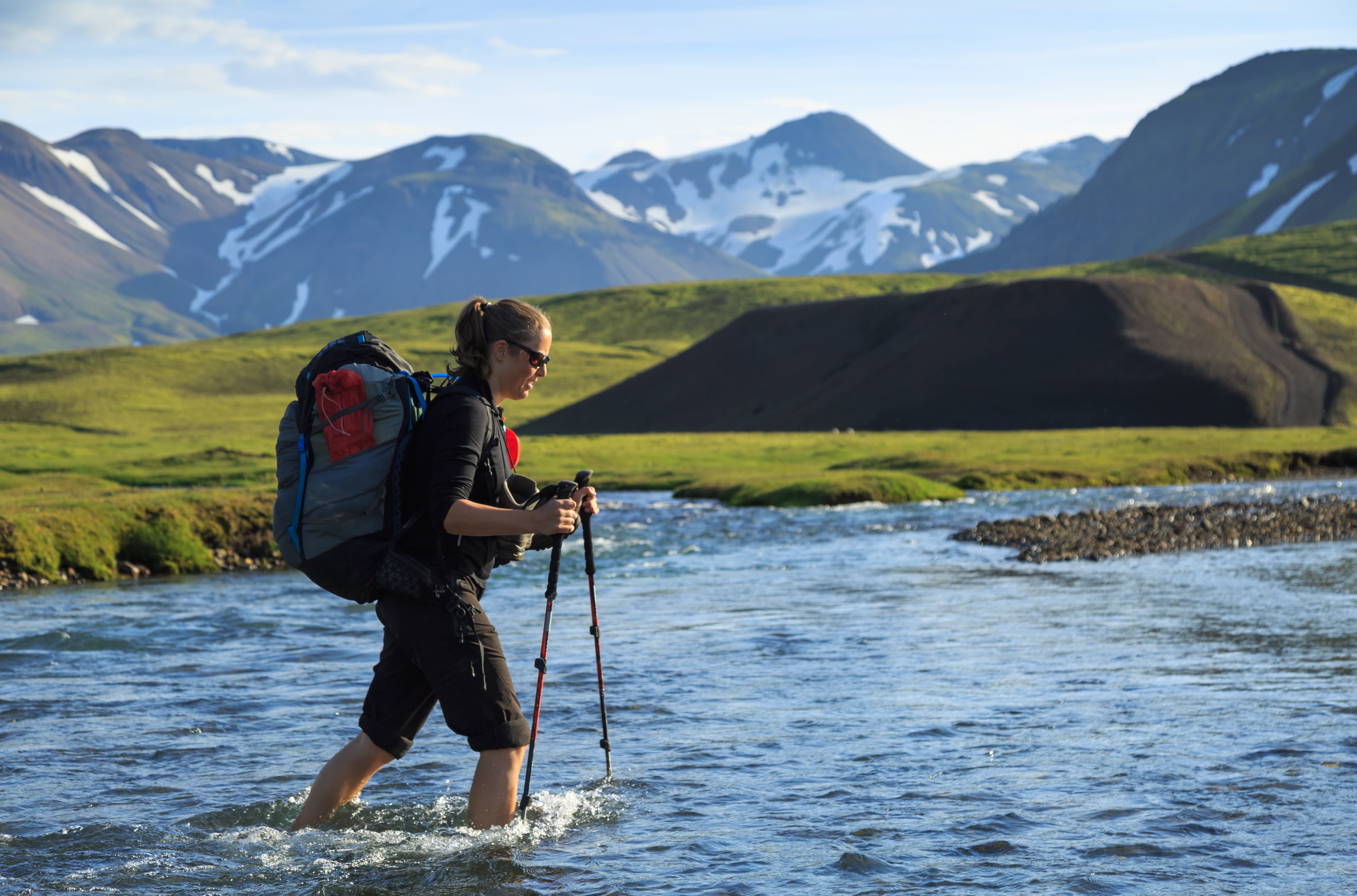 Female hiker crossing a river on the Laugavegur trail on Iceland. Female hiker crossing a river on the Laugavegur trail on Iceland.