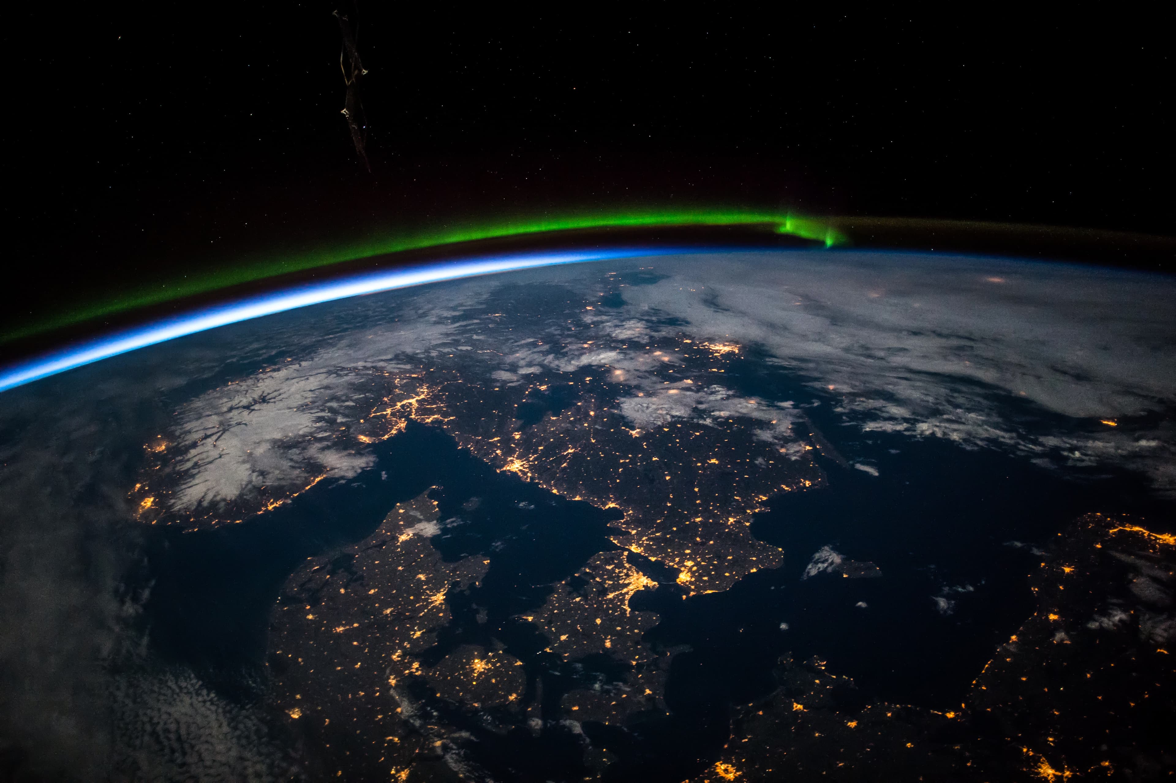 Aerial view from above Earth showing Scandinavia at night. Green aurora above the northern Baltic Sea. Image courtesy of the Earth Science and Remote Sensing Unit, NASA Johnson Space Center.