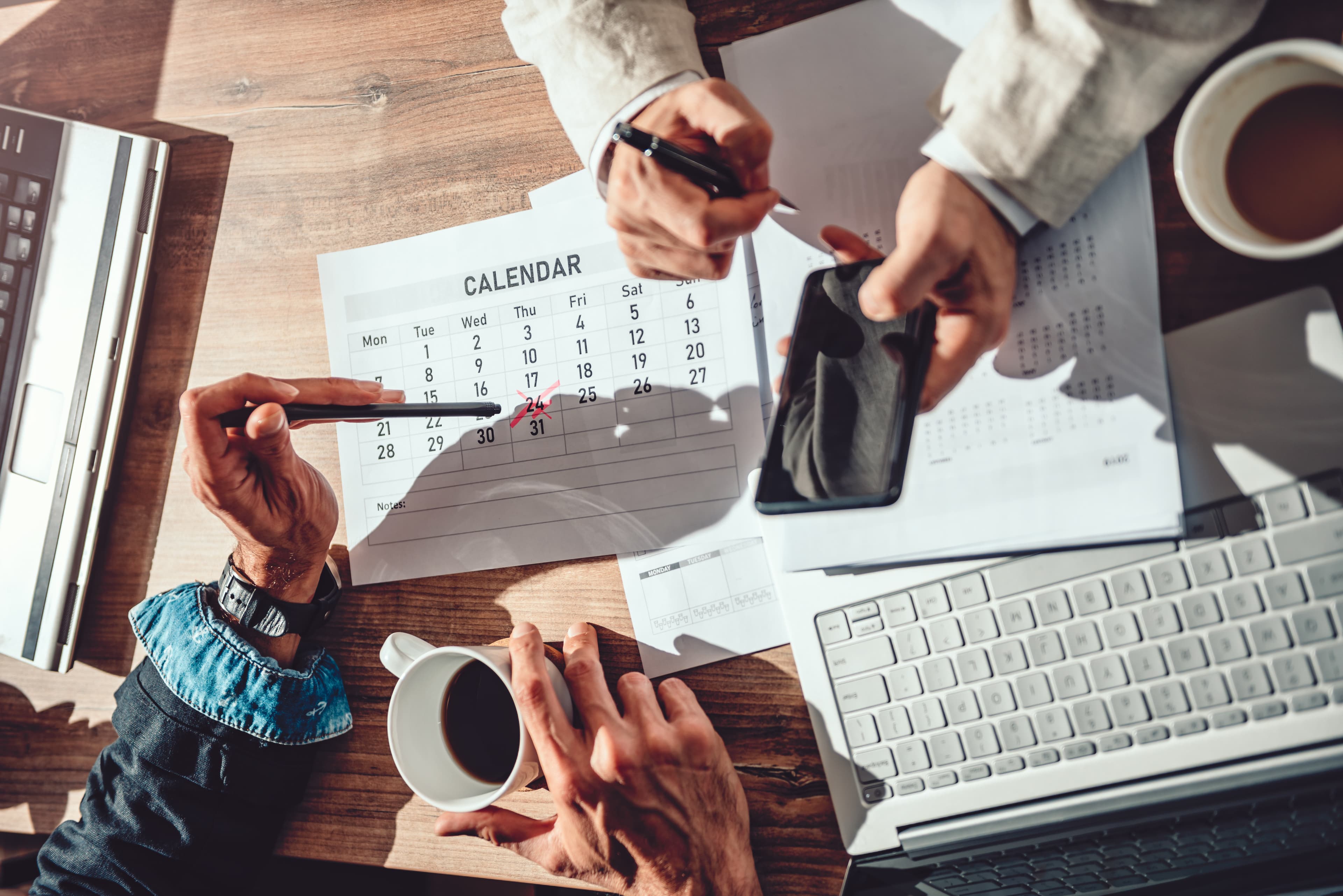 Two business people sitting at the desk and setting deadline for the next project Two business people setting deadline for a project