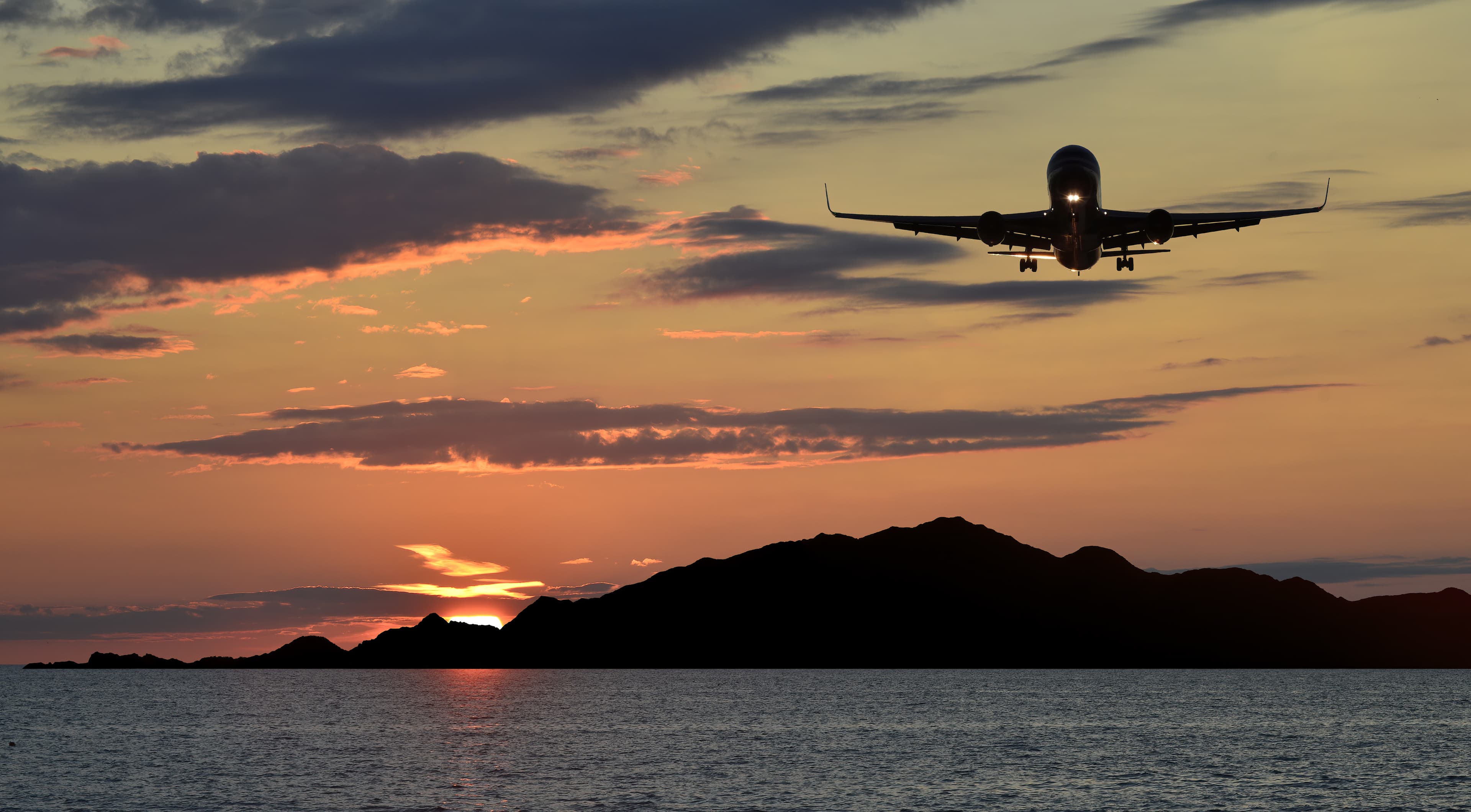 Landing airplane above Norwegian Sea near Alesund, Norway