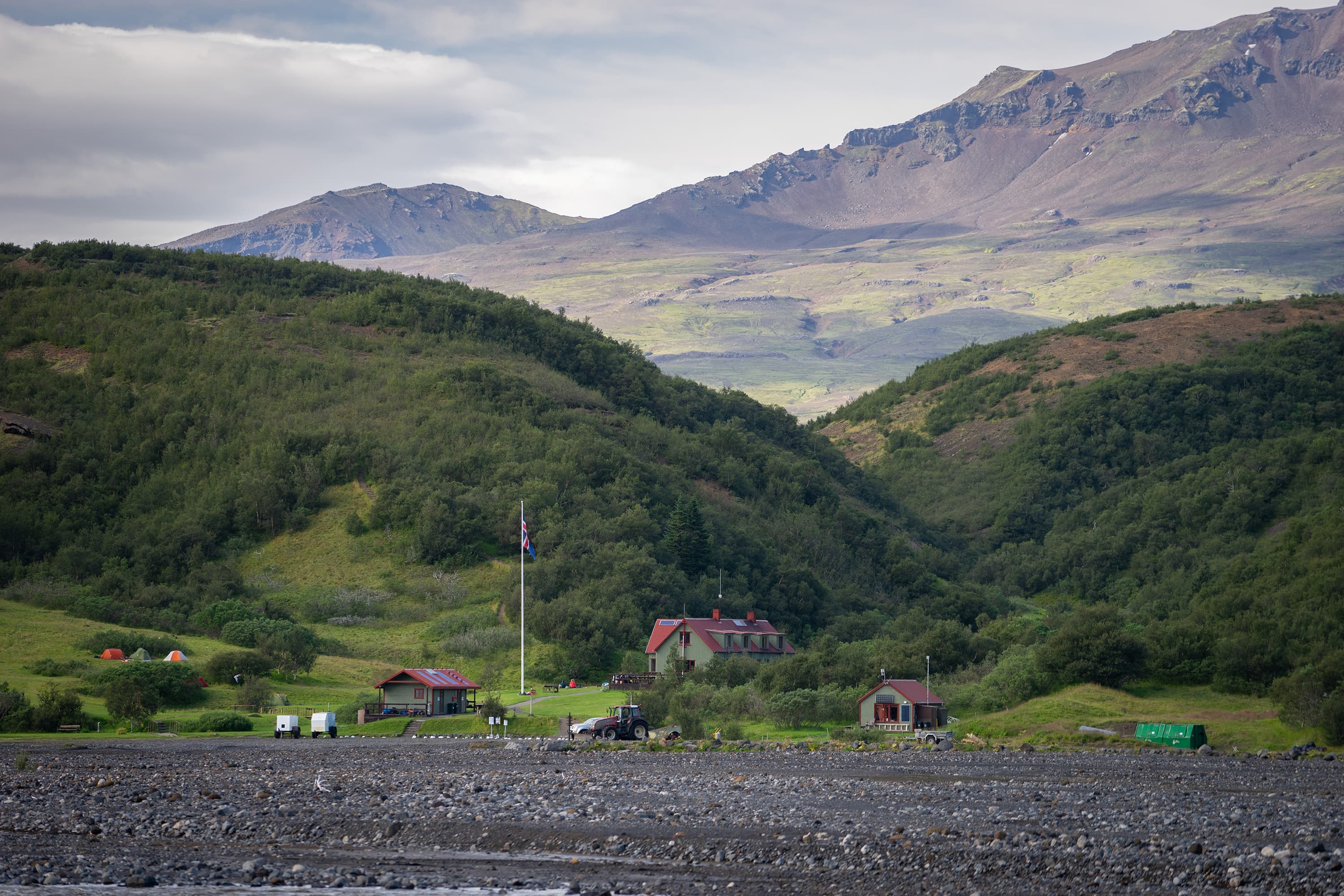 View of green hills and Camping side in Thorsmork Iceland. Camping tents, huts, cabins for tourists. View of green hills and Camping side in Thorsmork Iceland. Camping tents, huts, cabins for tourists