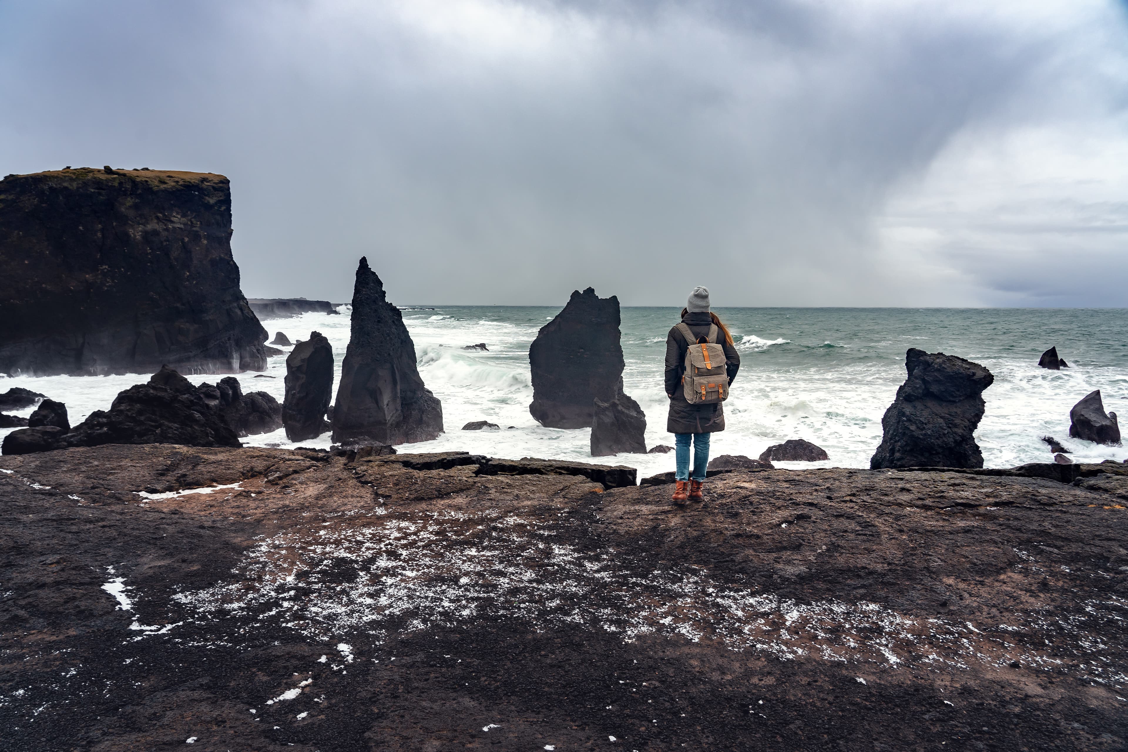 woman standing on the cliff and watching the power of the ocean on the reykjanesviti seacoast in Iceland . woman standing on the cliff and watching the power of the ocean on the reykjanesviti seacoast in Iceland