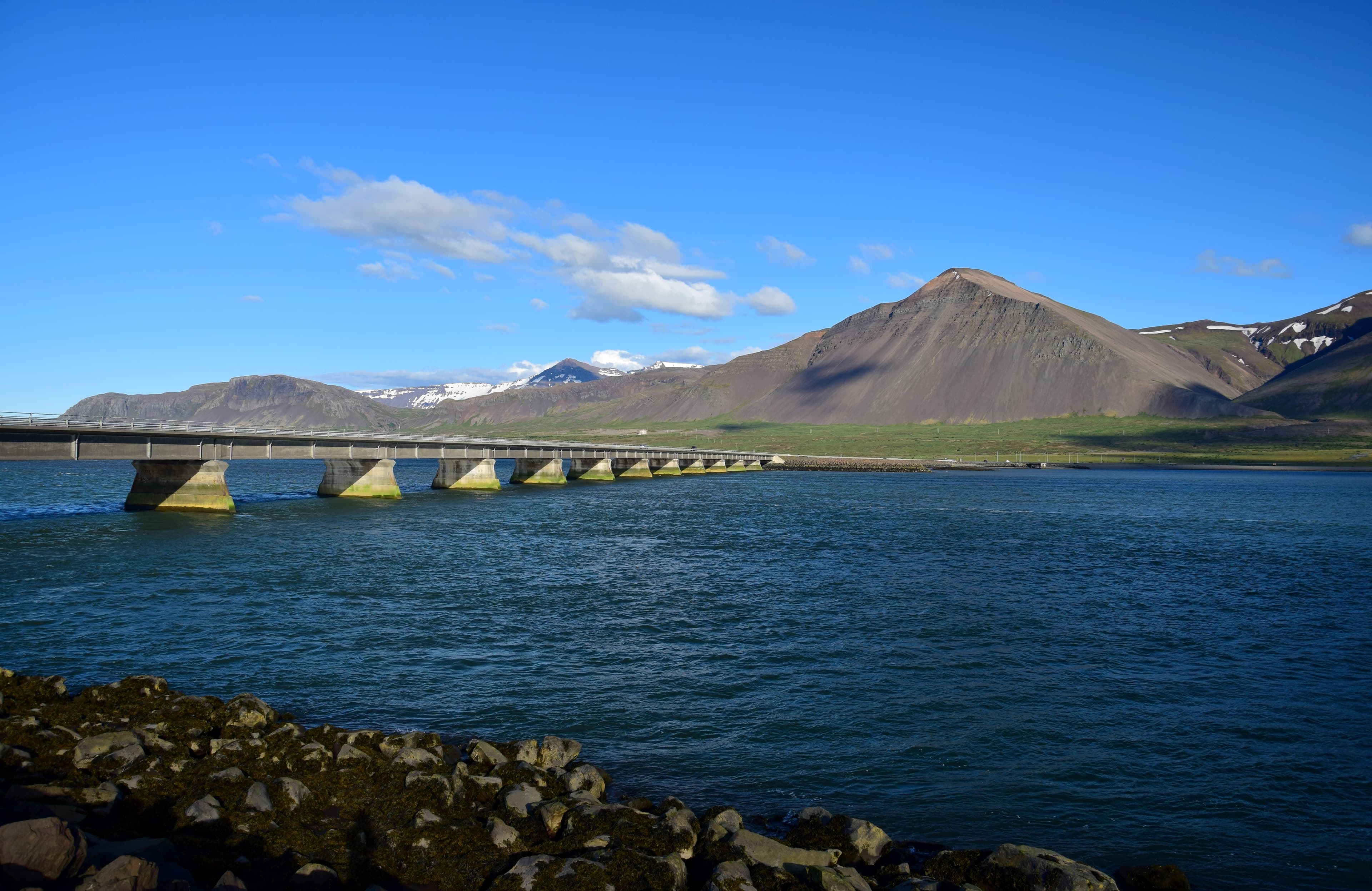 The girder bridge leading to Borgarnes in Iceland, crossing the ocean. Mountains in the background. The bridge over the ocean leading to Borgarnes, a town in Iceland.