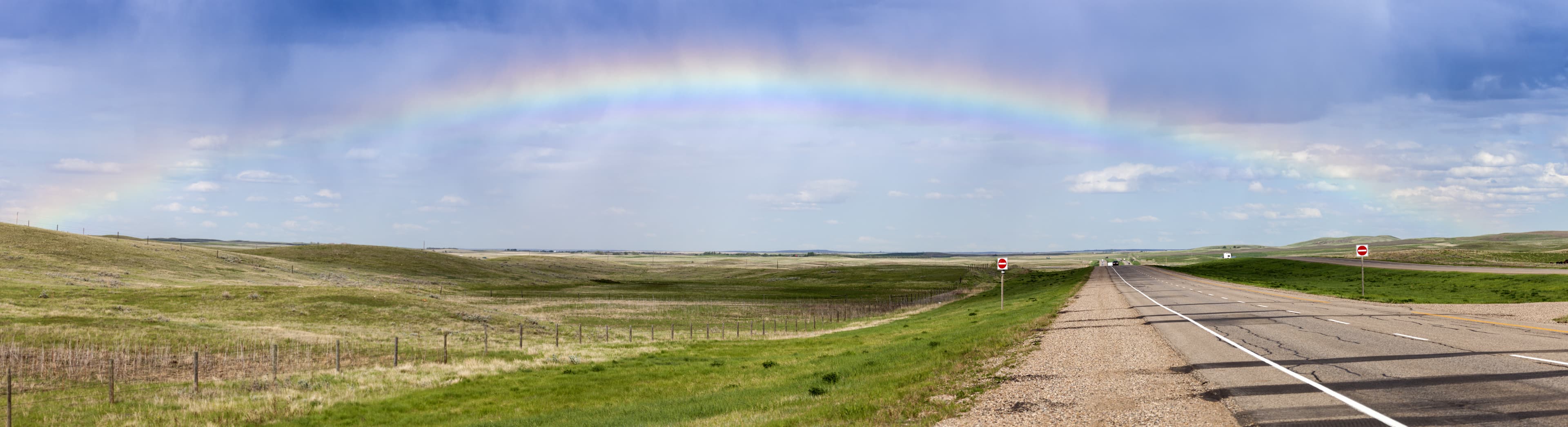 Rainbow over the highway in Saskatchewan. Saskatchewan, Canada. Saskatchewan Region 03