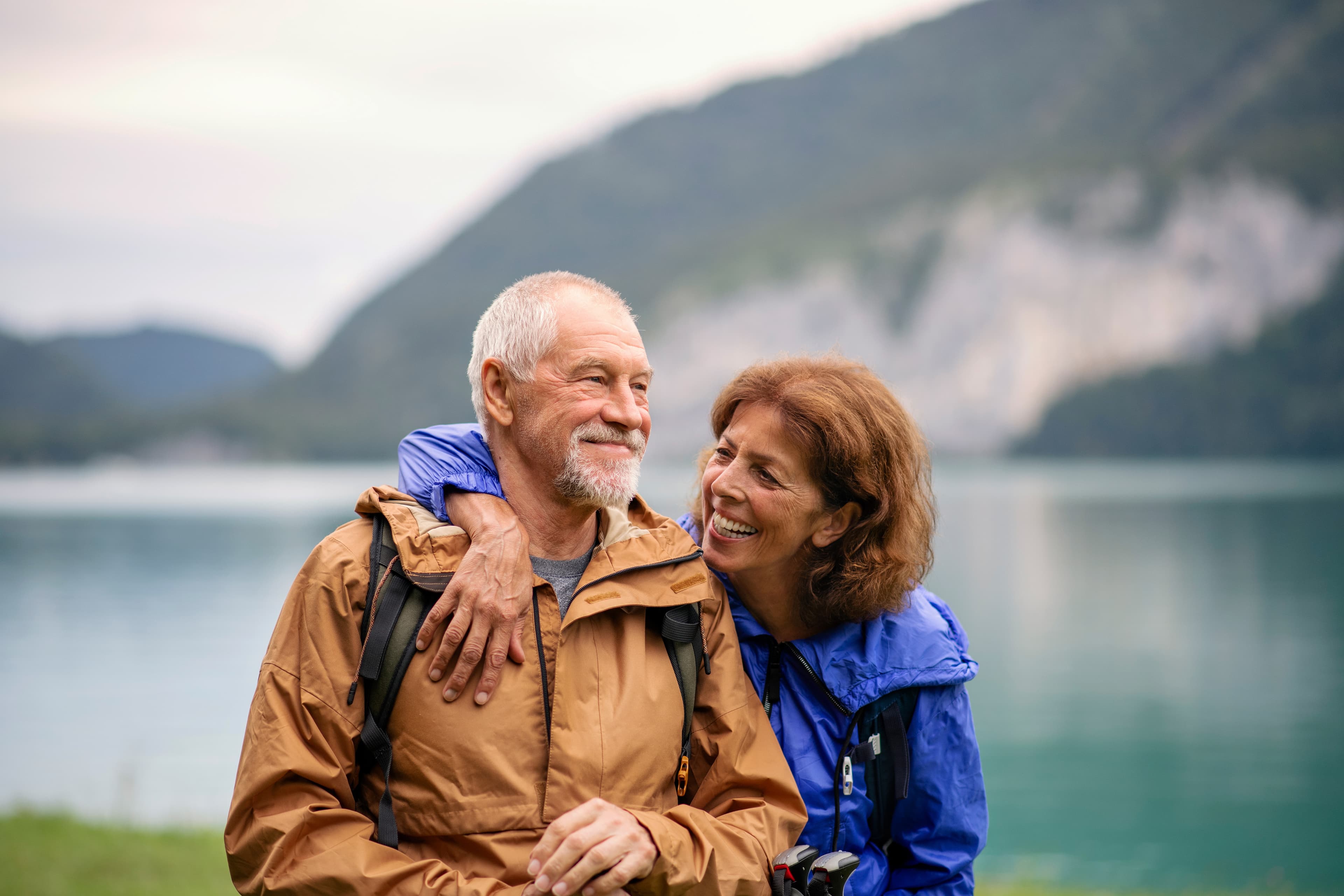 A senior pensioner couple hiking by lake in nature, resting. Senior pensioner couple hiking by lake in nature, resting.