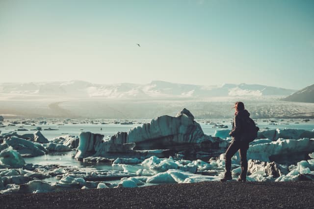 Woman explorer lookig at Jokulsarlon lagoon, Iceland Woman explorer lookig at Jokulsarlon lagoon, Iceland.