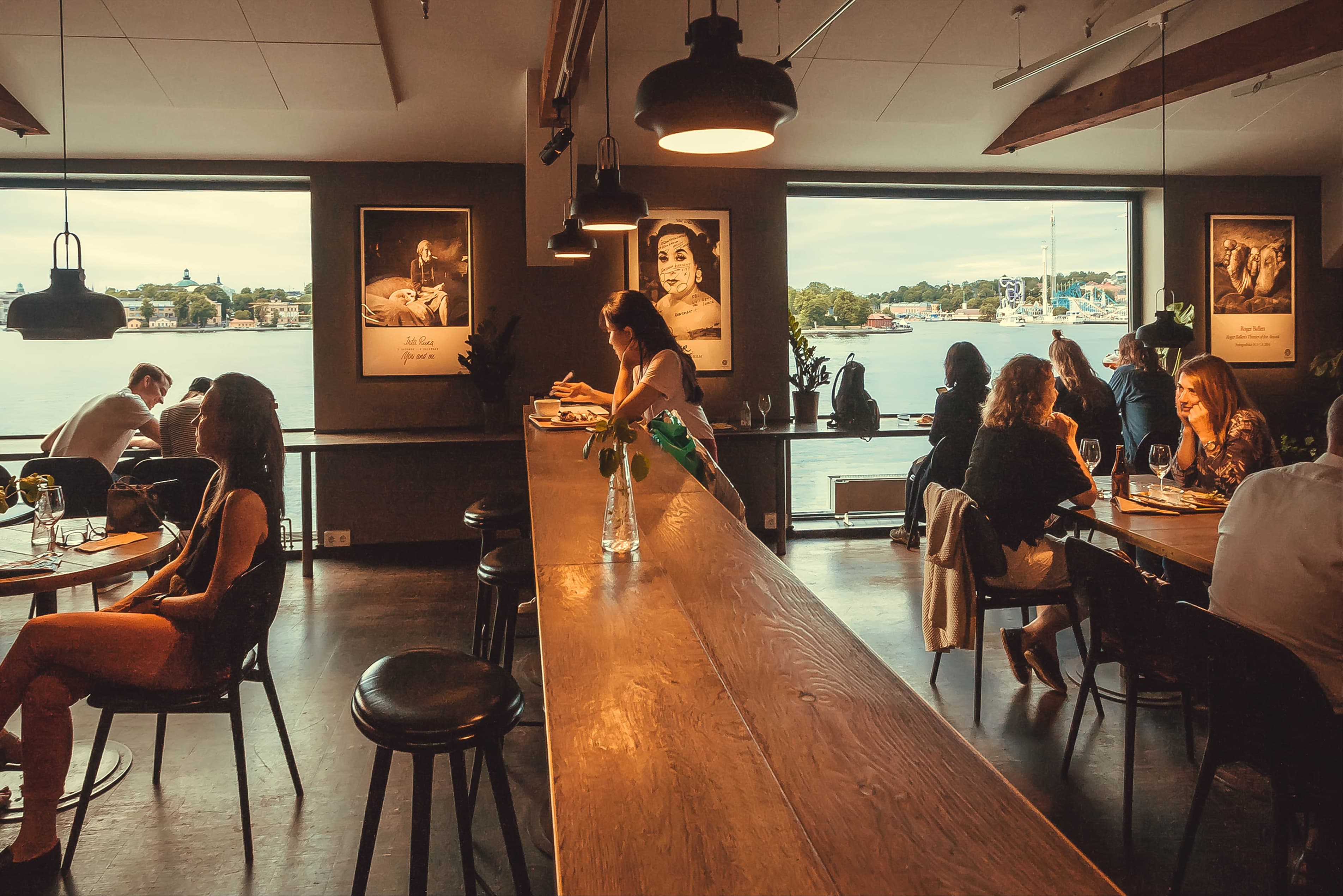 STOCKHOLM, SWEDEN - JUN 16, 2018: People drinking inside restaurant of the cultural center Fotografiska on June 16, 2018. Sweden with 10,5 million people ranks high in life expectancy STOCKHOLM, SWEDEN - JUN 16, 2018: People drinking inside restaurant of the cultural center Fotografiska on June 16, 2018. Sweden with 10,5 million people ranks high in life expectancy