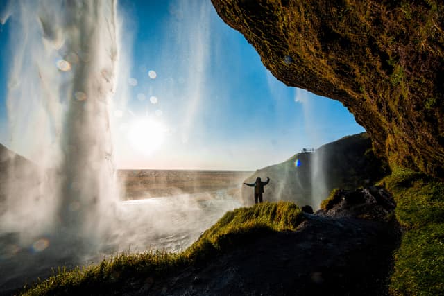 Tourist standing in front of Seljalandsfoss one of the best known waterfalls in southern Iceland, The most famoust Icelandic waterfall , beautiful amazing landscape from Iceland, Tourist standing in front of Seljalandsfoss one of the best known waterfalls in southern Iceland, Seljalandsfoss , Iceland