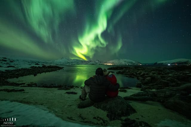People-watching-northern-lights-by-lake