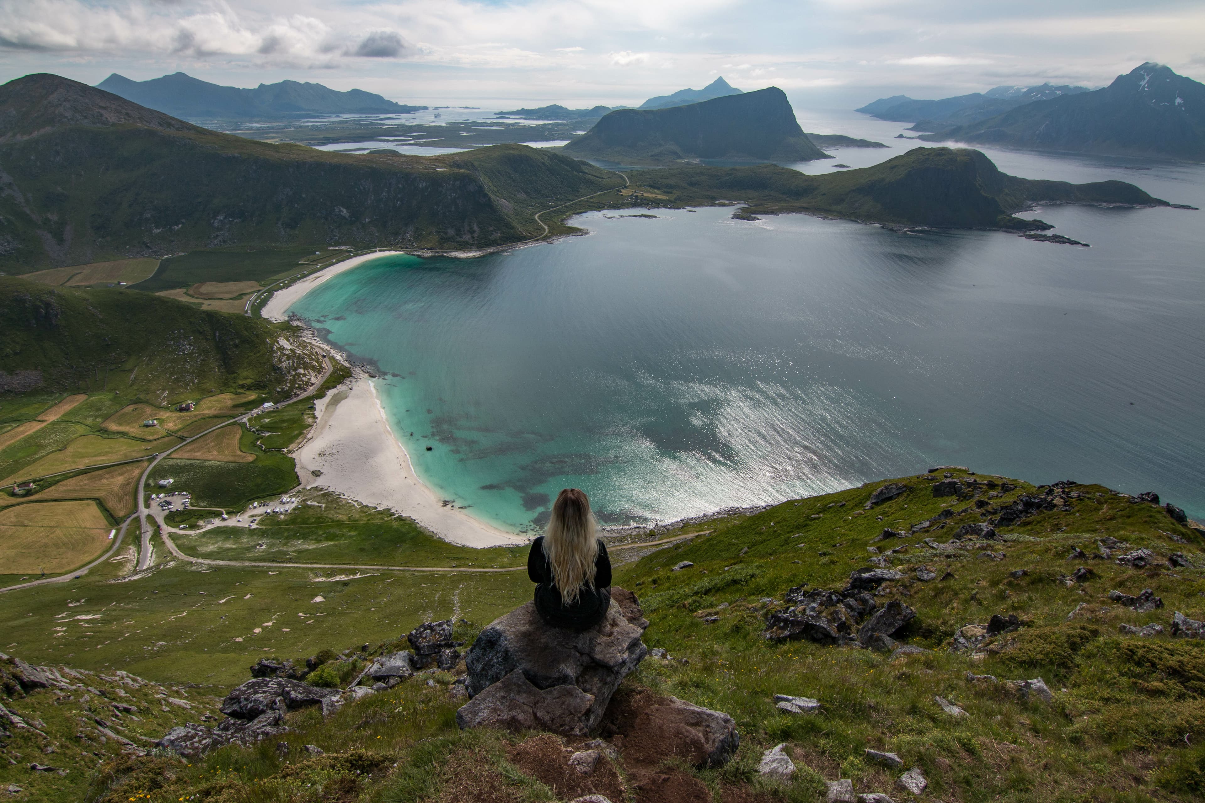 Woman enjoying an amazing view towards Haukland Beach on the Lofoten Islands during summer in Norway