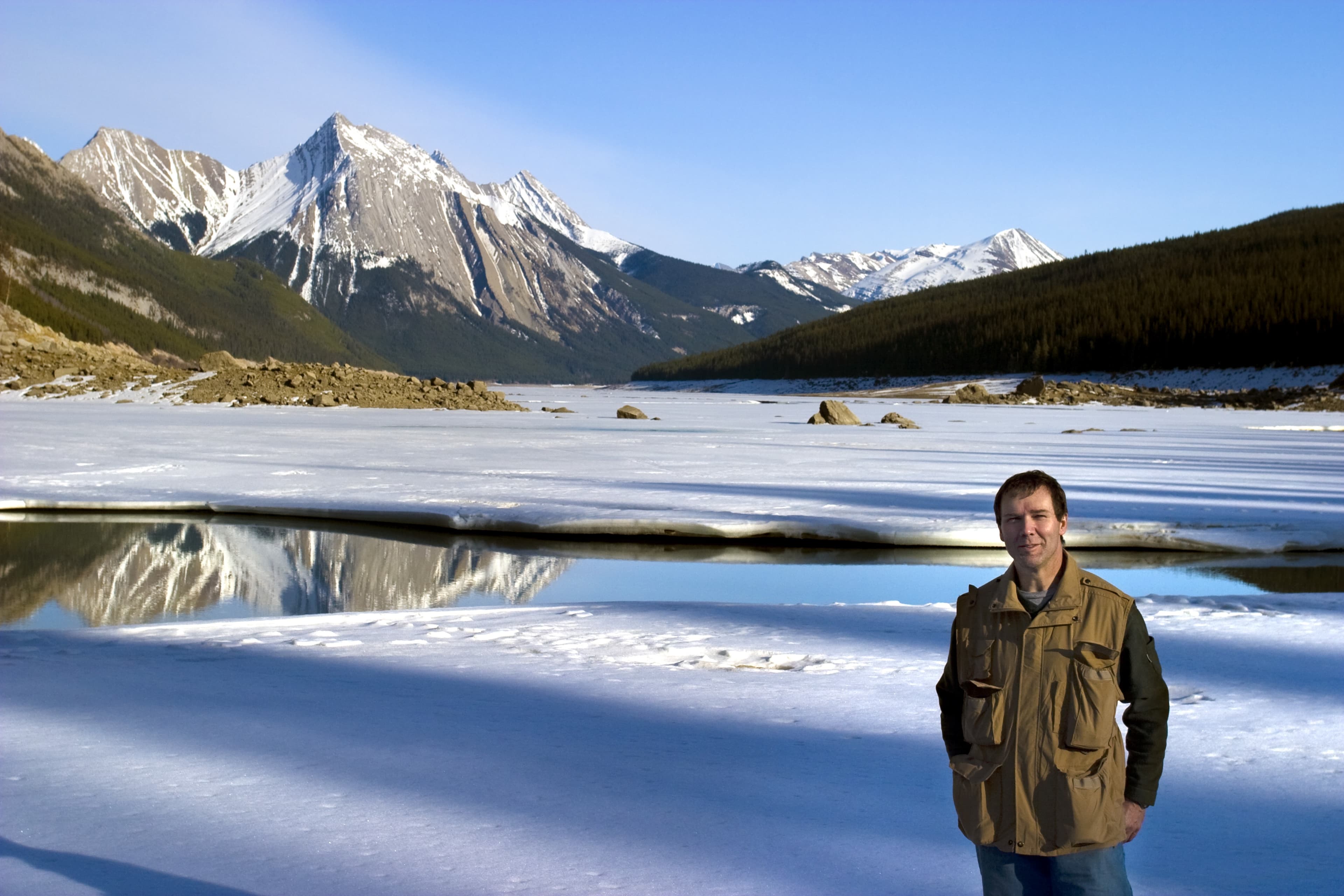 Man Standing In Front Of Medicine Lake, Alberta, Canada Man Standing In Front Of Medicine Lake,Alberta,Canada
