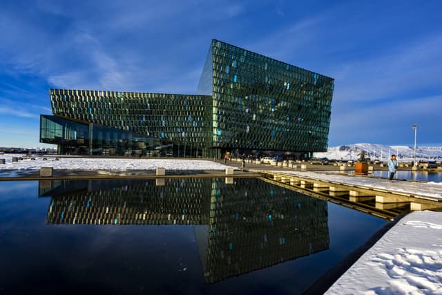 Fantastic picturesque sunset over majestic Harpa Concert Hall and building reflection. Famous travel locations. Reykjavik, Iceland