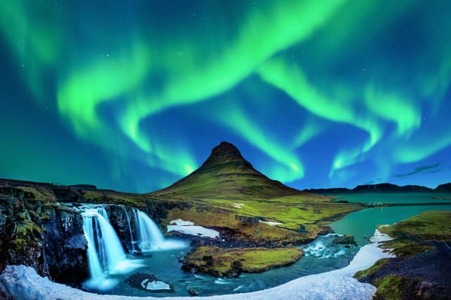 Northern Light, Aurora borealis at Kirkjufell in Iceland. Kirkjufell mountains in winter. Iceland-norther-lights-above-Kirkjufell-mountain-and-waterfall