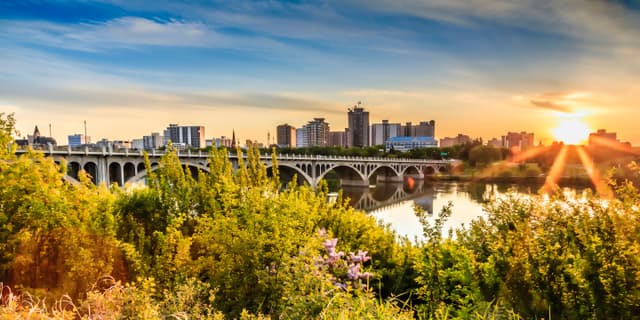 A warm summer sunset over the city of Saskatoon located in Central Canada where the calm waters of the South Saskatchewan River flows under the University Bridge. Saskatoon City Attraction 5