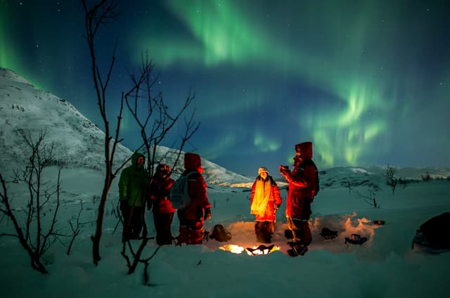 People-by-campfire-watching-northern-lights