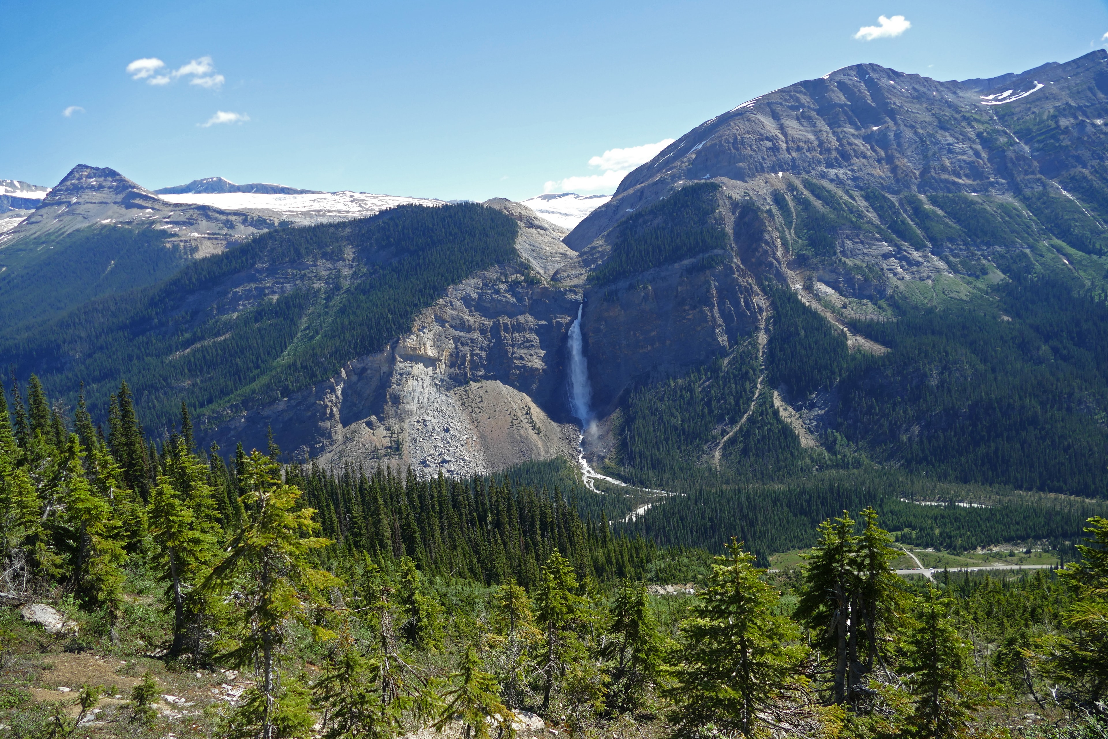 Magnificent Takakkaw Falls in Yoho National Park landscape with rugged mountains, spruce trees and blue sky, summer tourist hiking destination, Canadian Rockies, British Columbia, Canada Magnificent Takakkaw Falls in Yoho National Park landscape with rugged mountains, spruce trees and blue sky, summer tourist hiking destination, Canadian Rockies, British Columbia, Canada