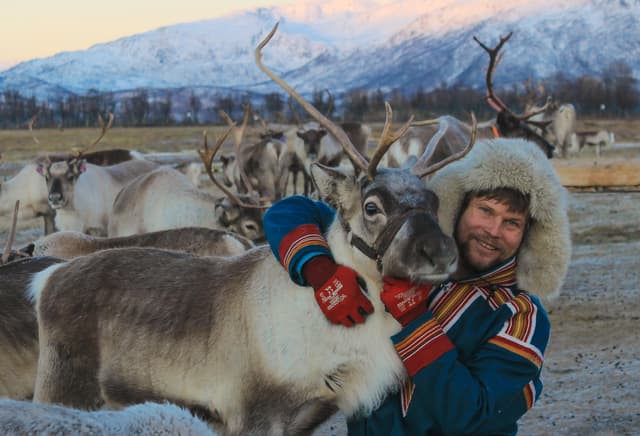 Man-holding-reindeer-for-taking-a-photo
