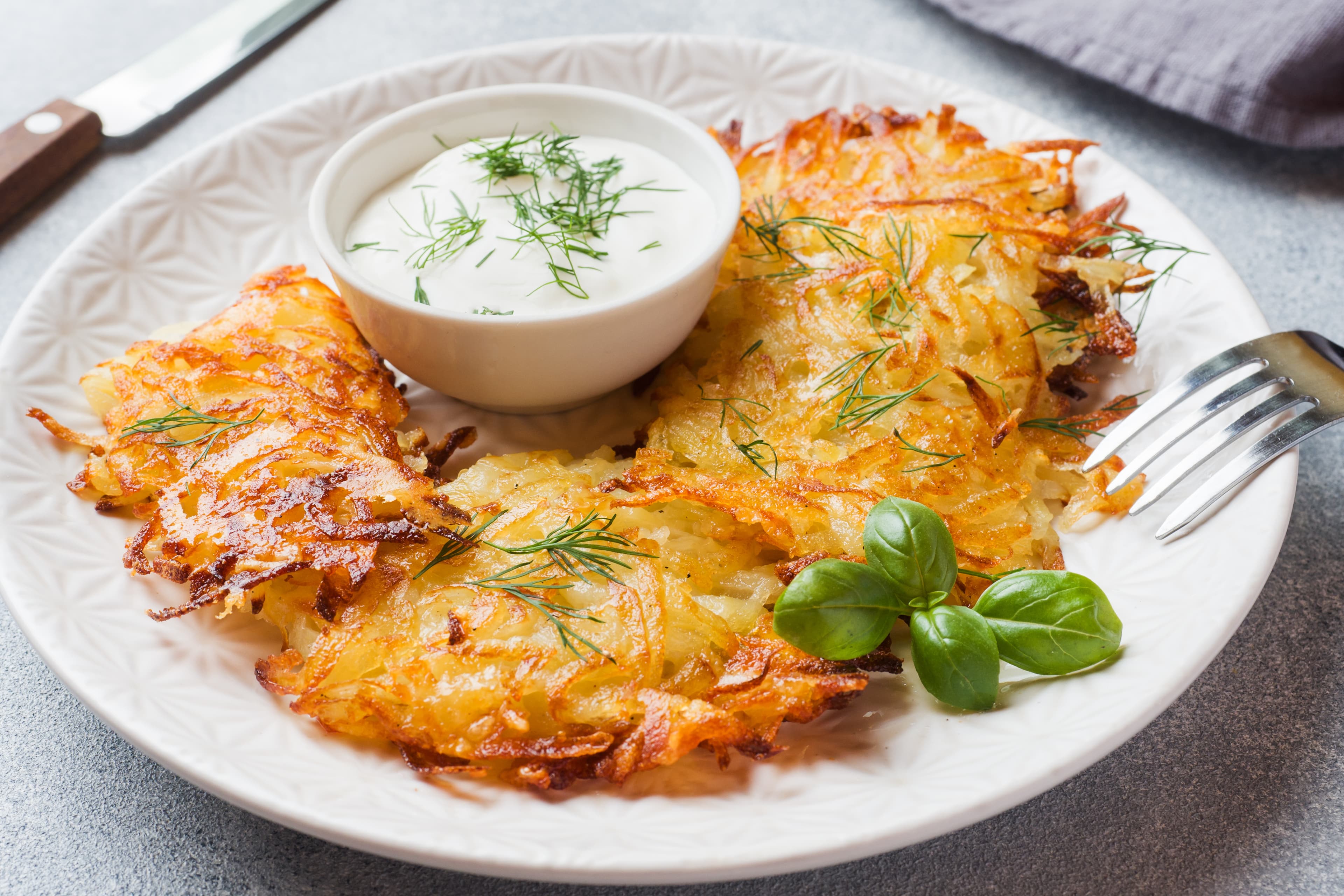 Fried cakes of grated potatoes on the plate with sauce. Traditional pancakes boxty raggmunk. Fried cakes of grated potatoes on the plate with sauce. Traditional pancakes boxty raggmunk