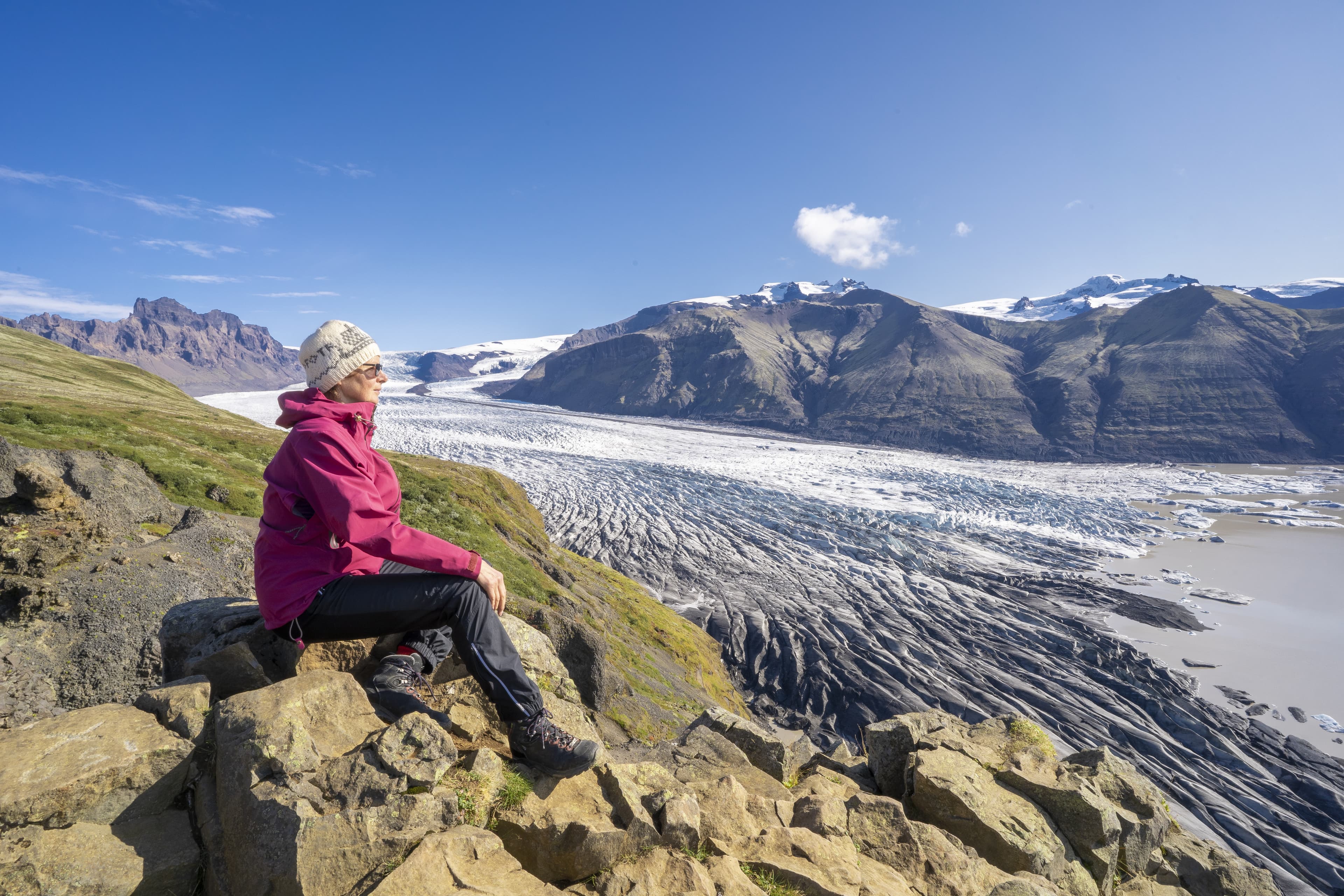 active senior woman, resting above Vatnajokull glacier with Skaftafell glacier tongue in Iceland
