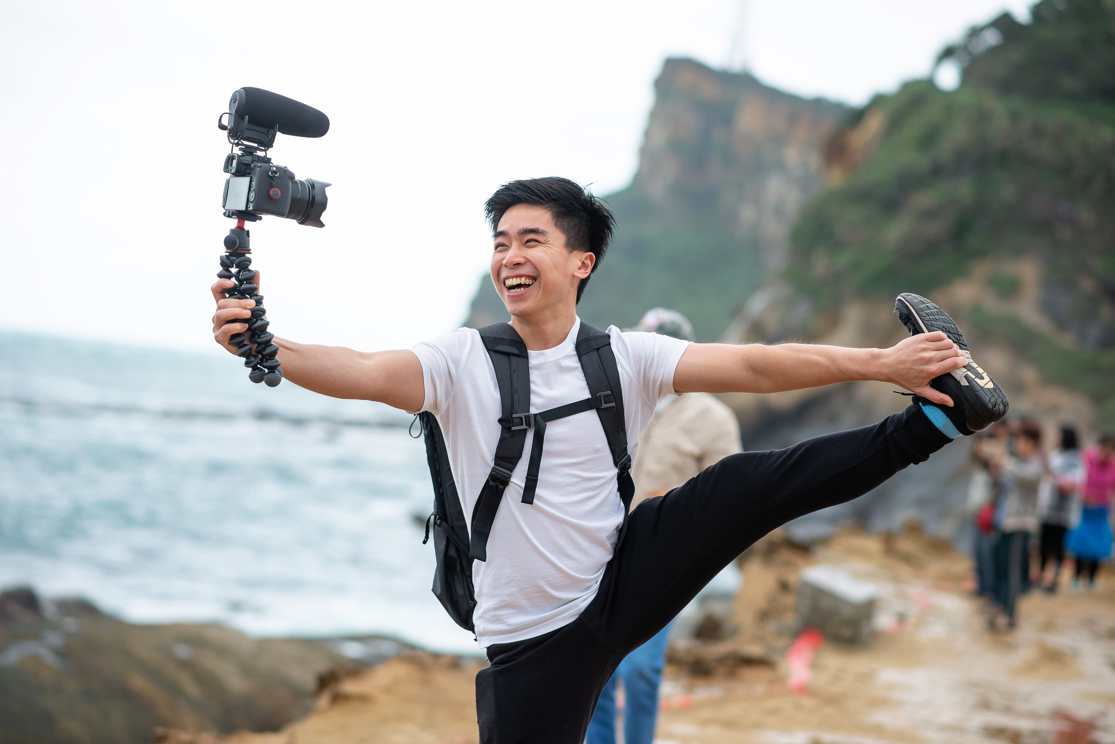 Vlogger holds and smile with his camera Vlogger holds and smile with his camera