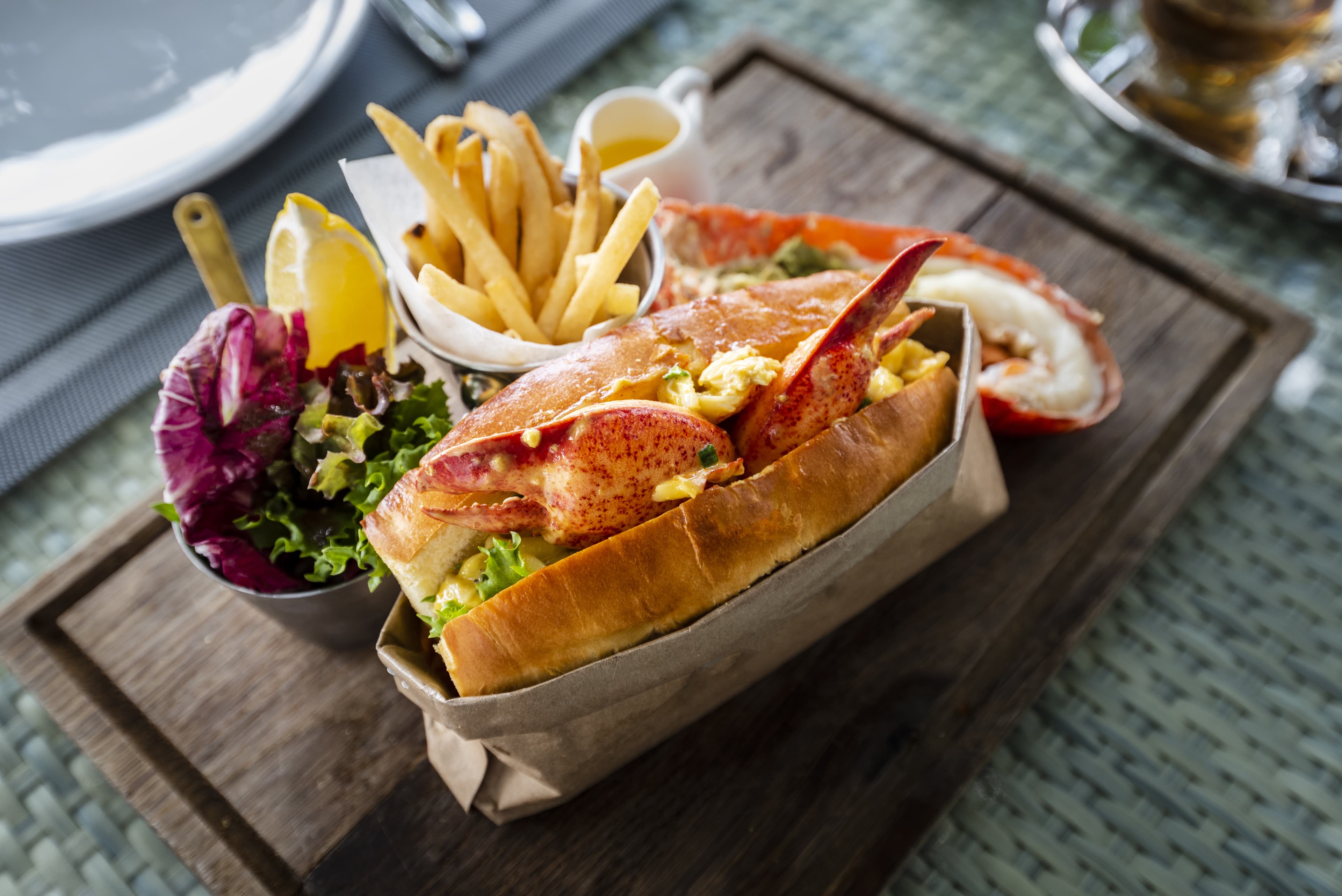 Delicious lobster roll sandwich Served with a side of French Fries and fresh salad. New England lobster roll Delicious lobster roll sandwich Served with a side of French Fries and fresh salad. New England lobster roll