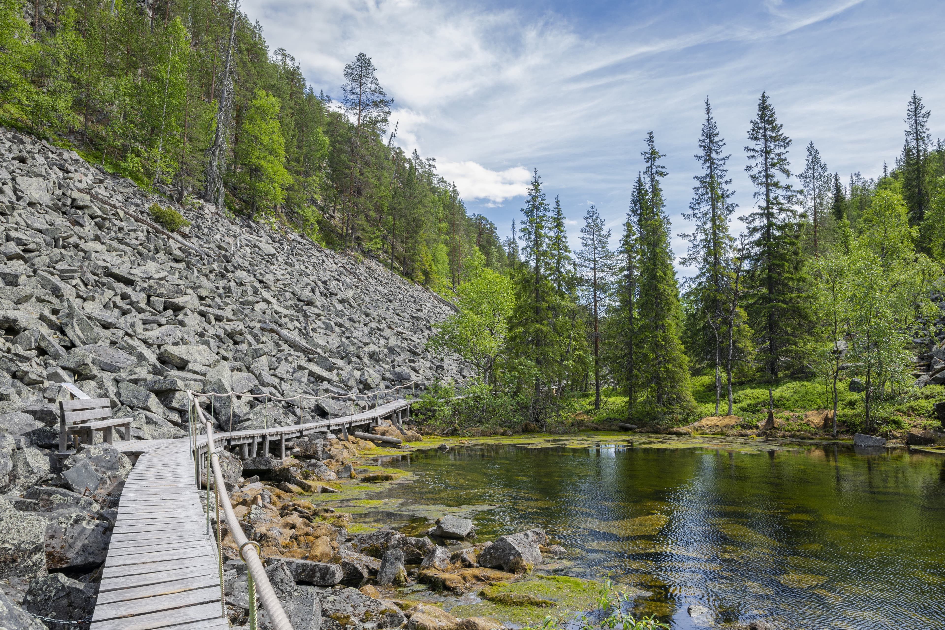 View of The Pyha-Luosto National Park in summer, rocks, stones, trees, wooden walkway and natural pond, Lapland, Finland View of The Pyha-Luosto National Park in summer, rocks, stones, trees, wooden walkway and natural pond, Lapland, Finland